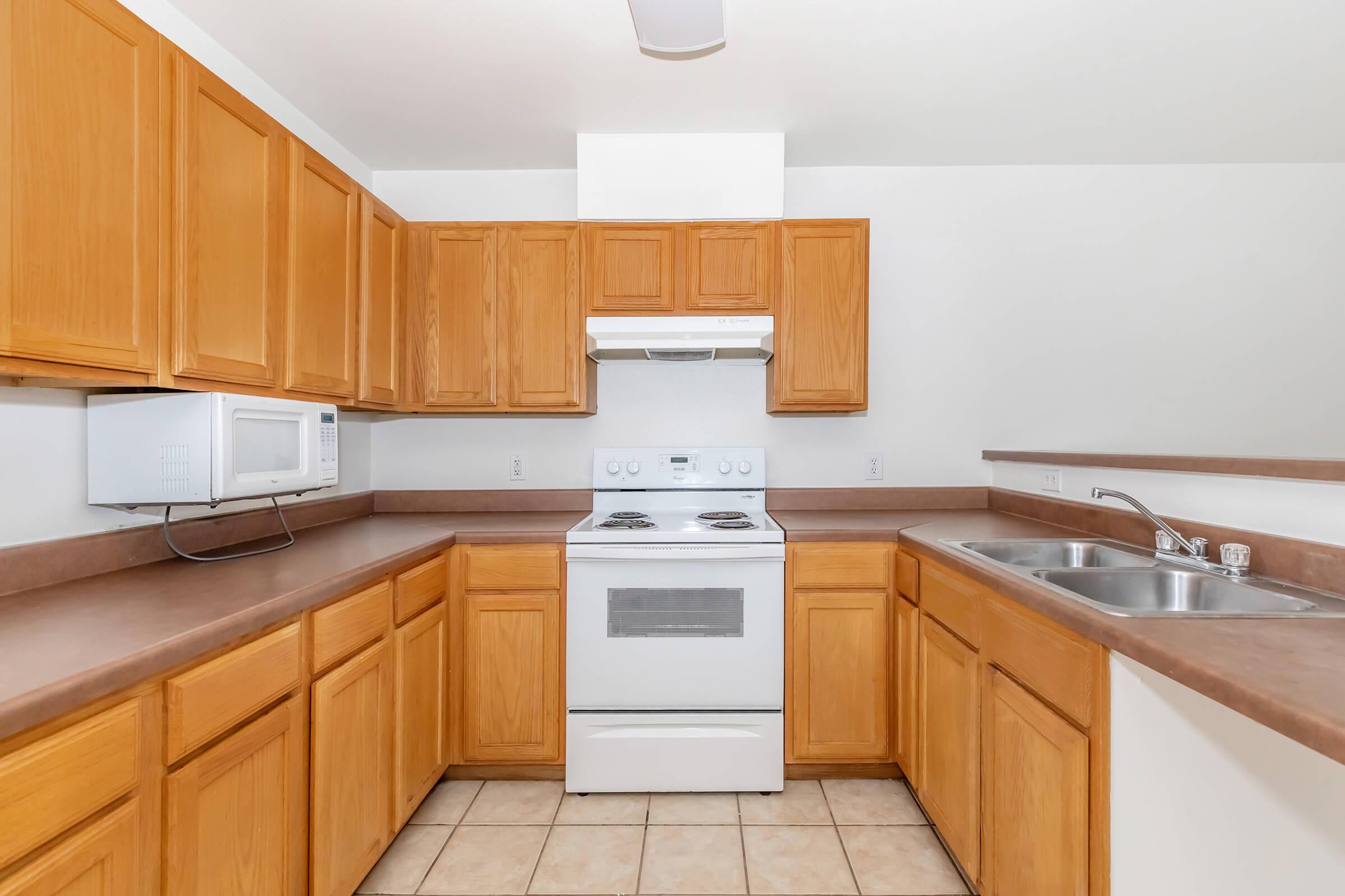 a kitchen with a stove refrigerator and wooden cabinets