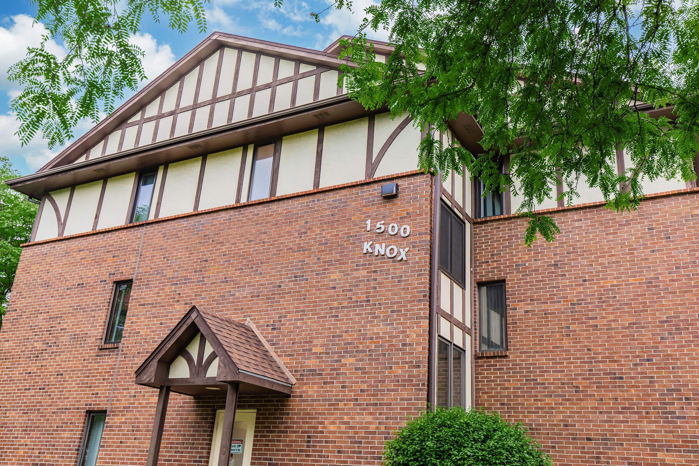 a large brick building with a clock on the front of a house