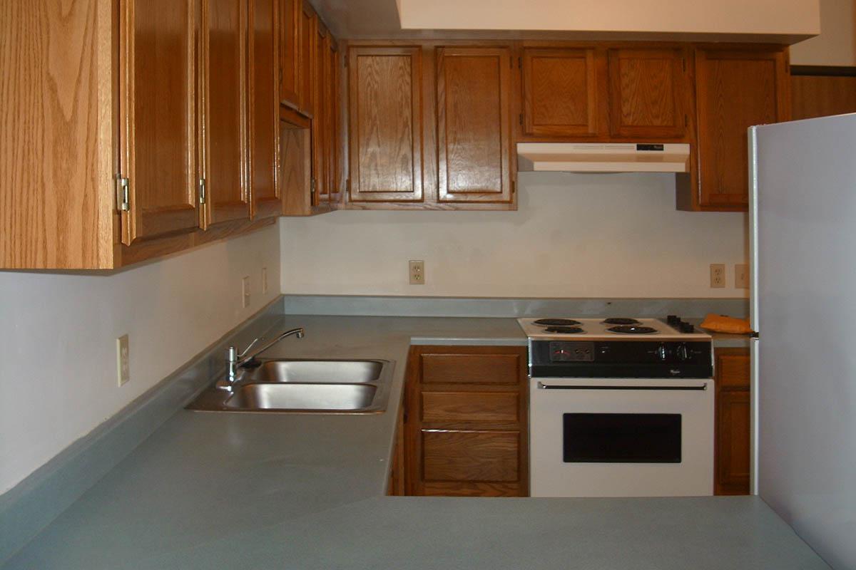 a kitchen with wooden cabinets and a microwave