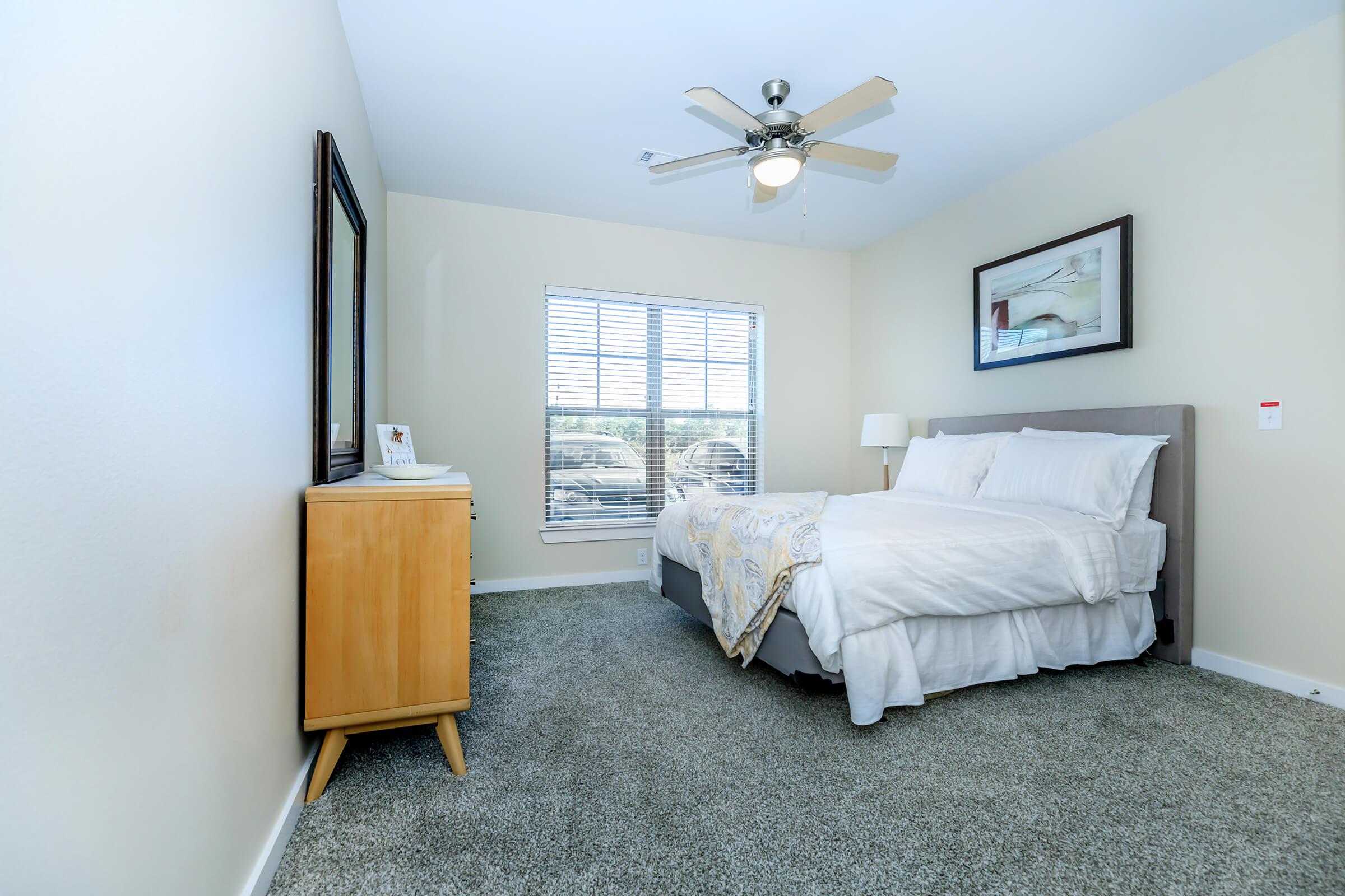 a bedroom with a bed and desk in a room