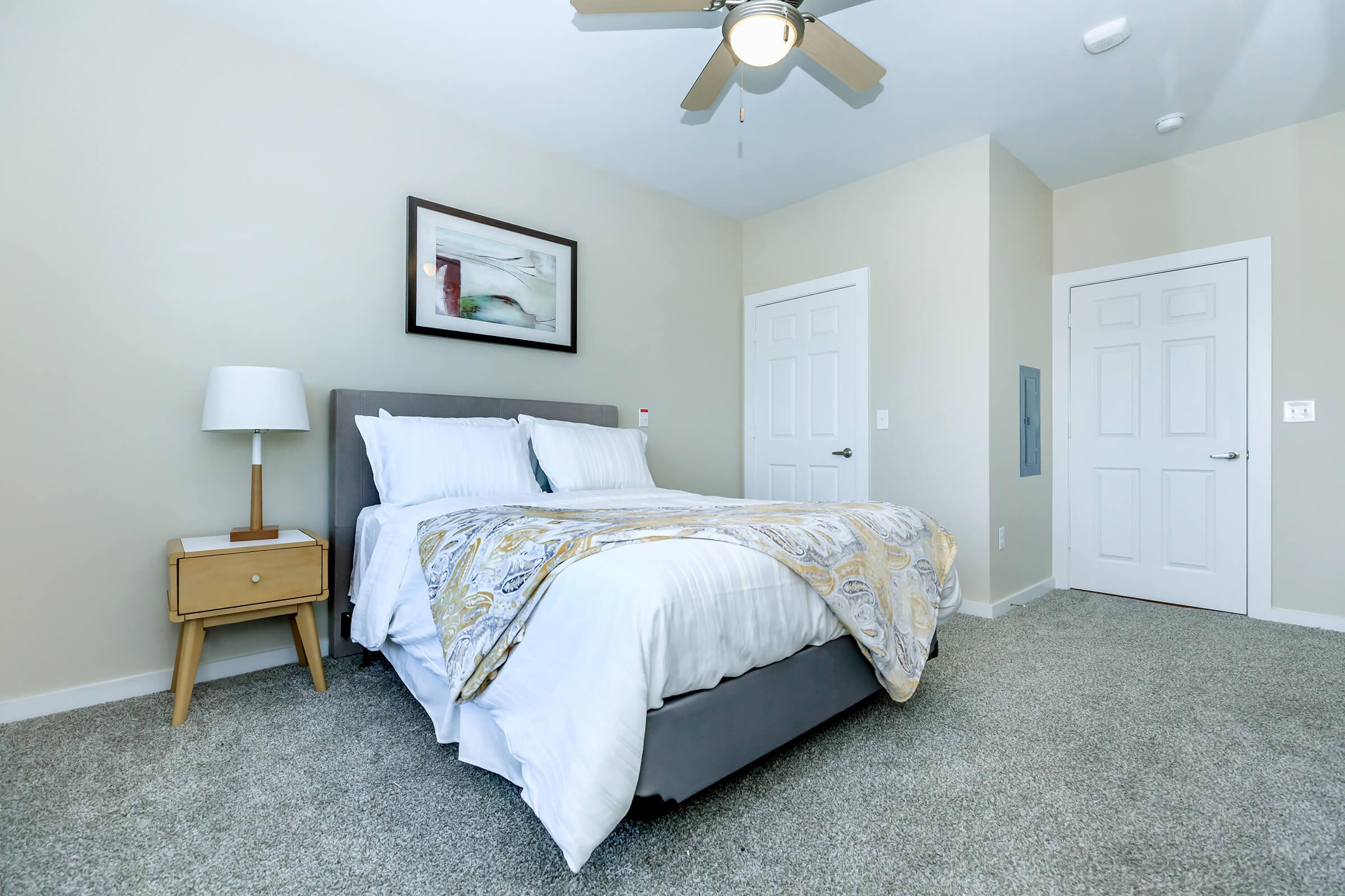 a bedroom with a bed and desk in a room