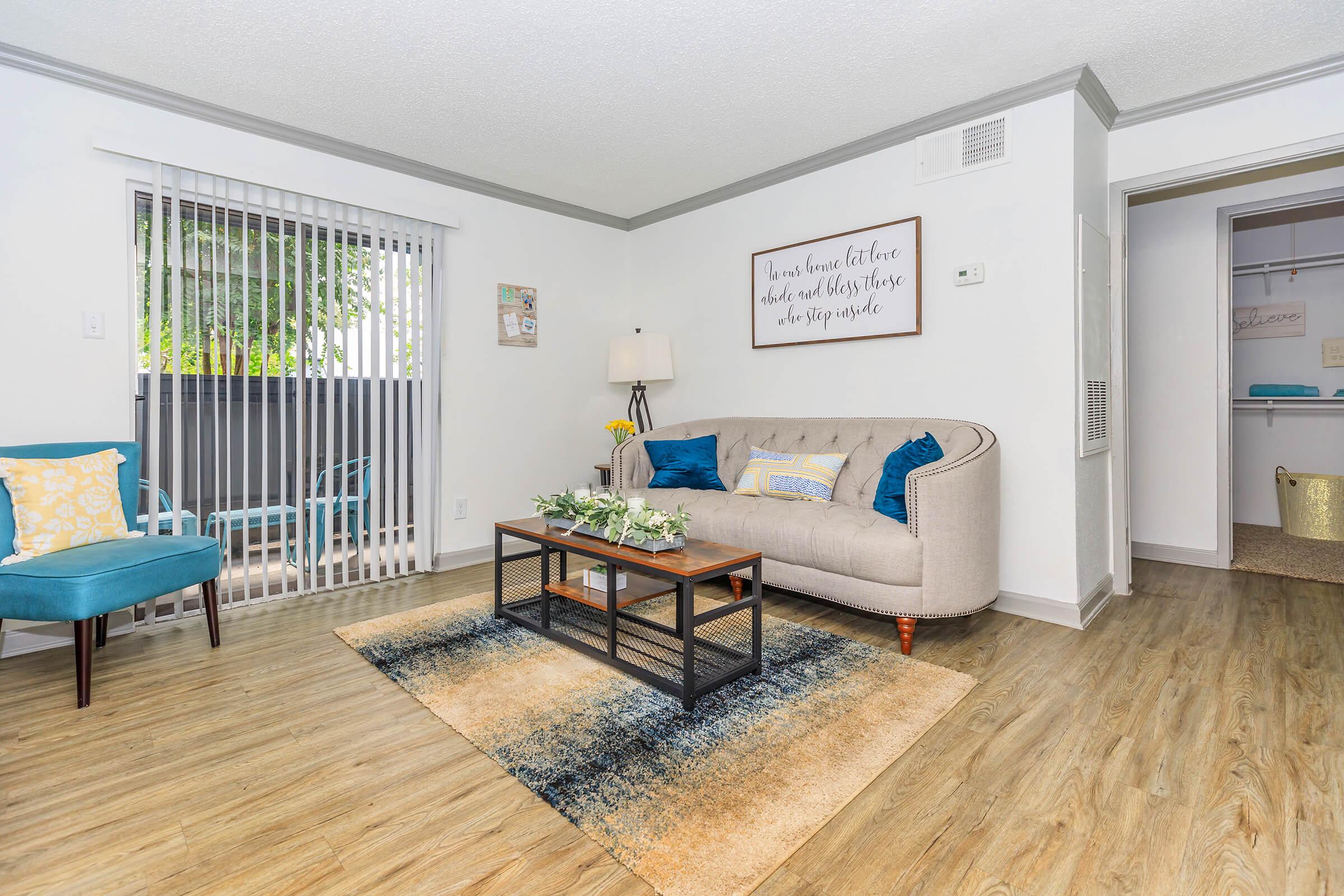 a living room filled with furniture on top of a wooden floor