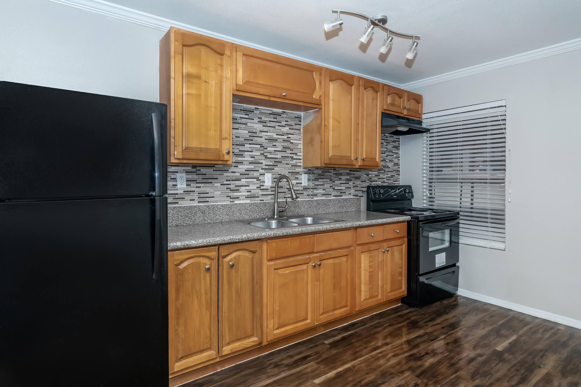 a large kitchen with stainless steel appliances and wooden cabinets