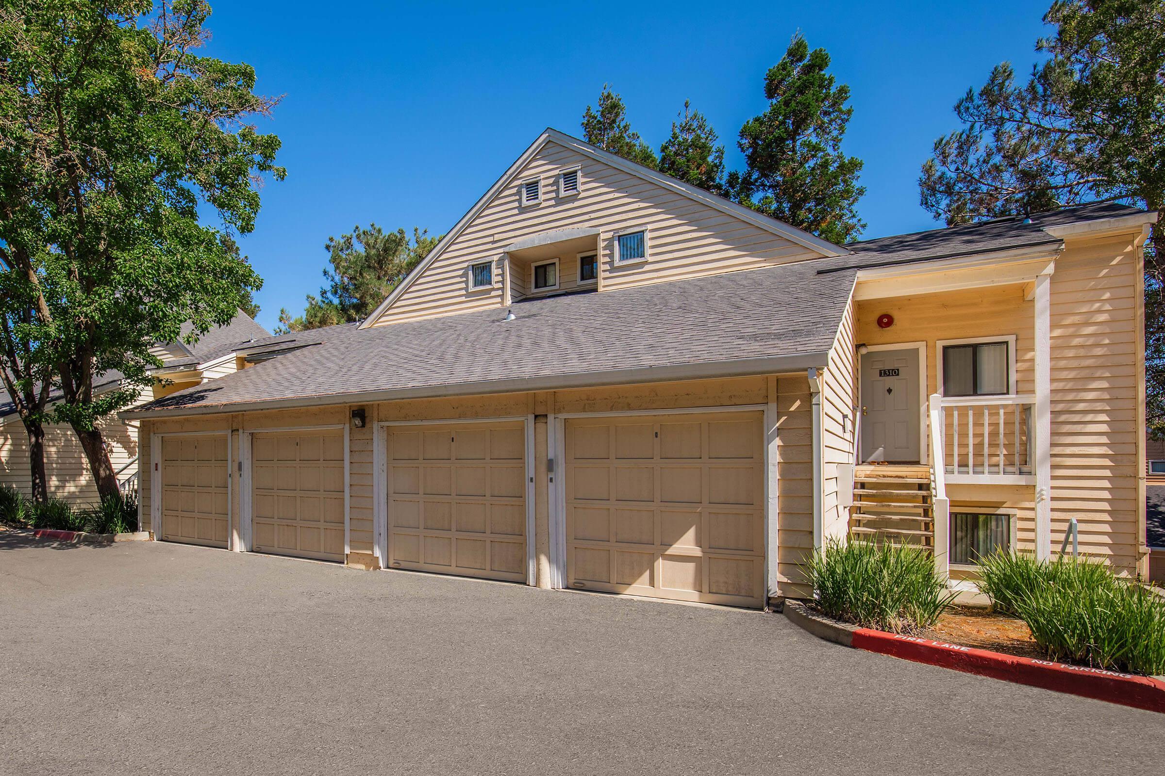 a house with trees in front of a brick building