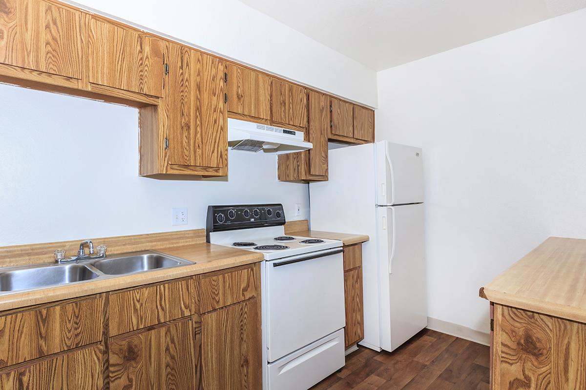 a kitchen with wooden cabinets and a refrigerator