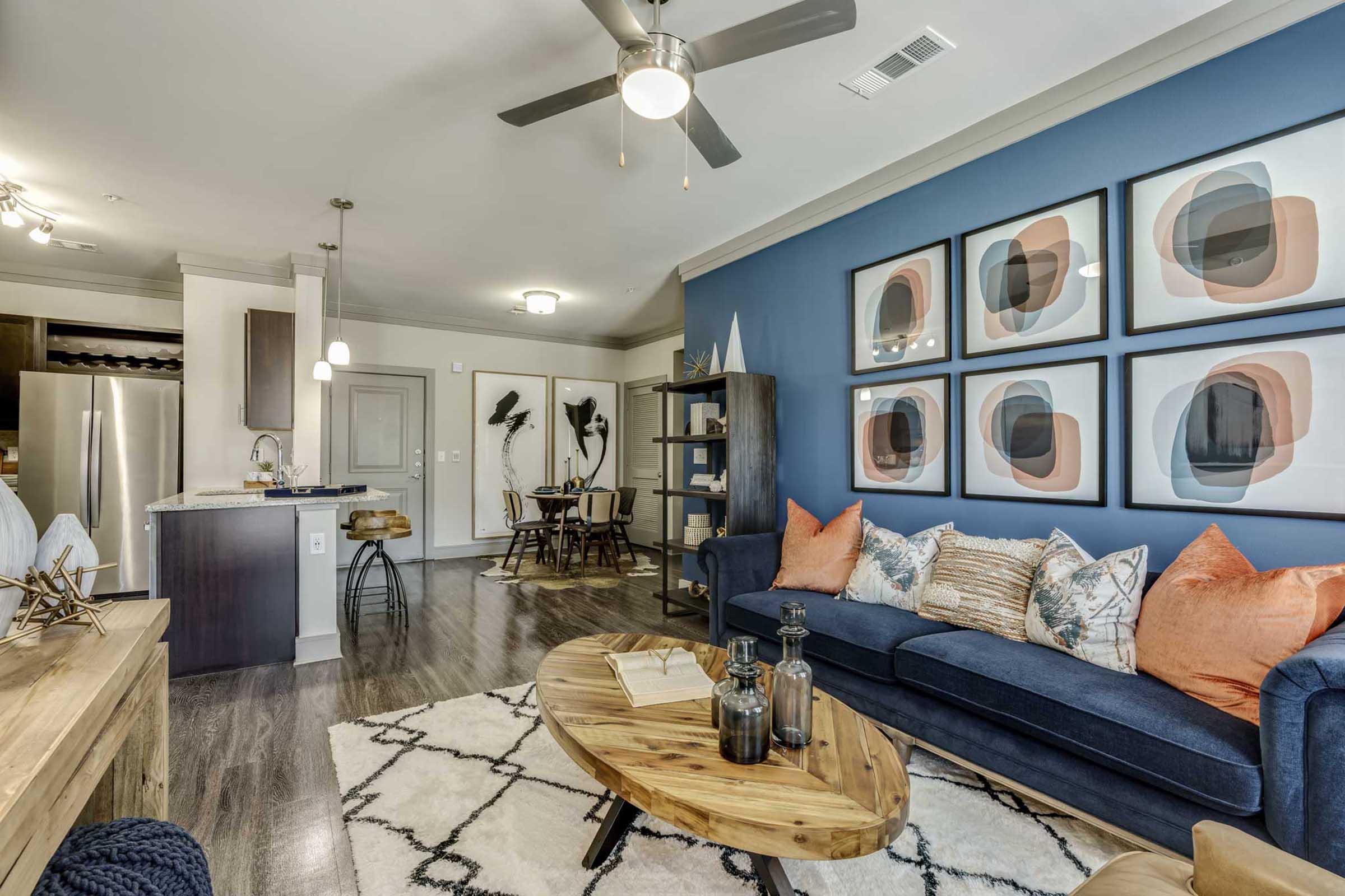 A modern living room featuring a navy blue accent wall with framed artwork.