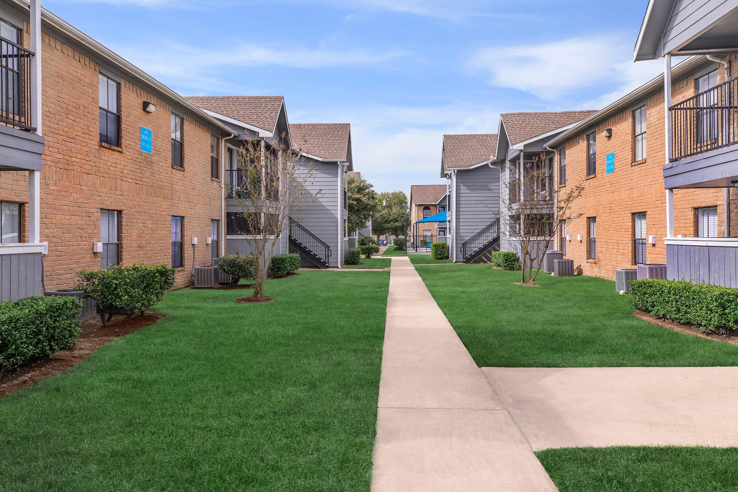 a large lawn in front of a brick building