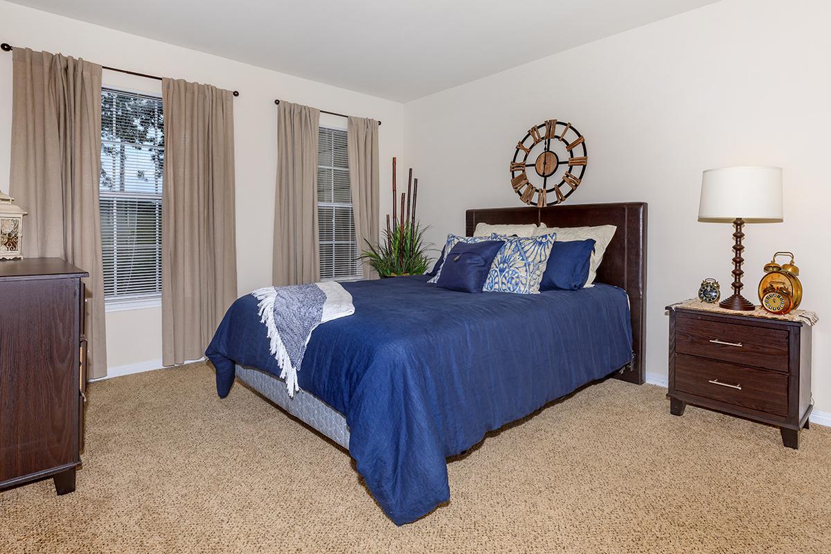 a bedroom with a bed and desk in a room