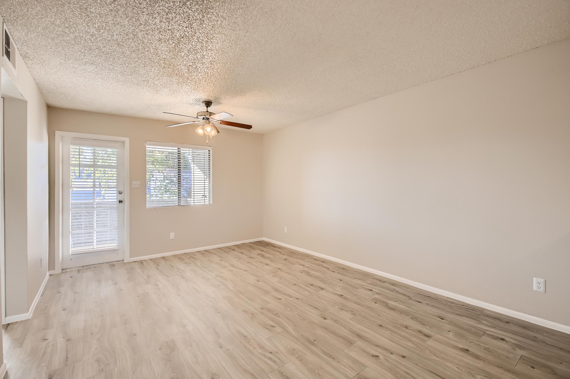 Phoenix apartment empty white room with a wooden floor, window, door and ceiling fan in the front