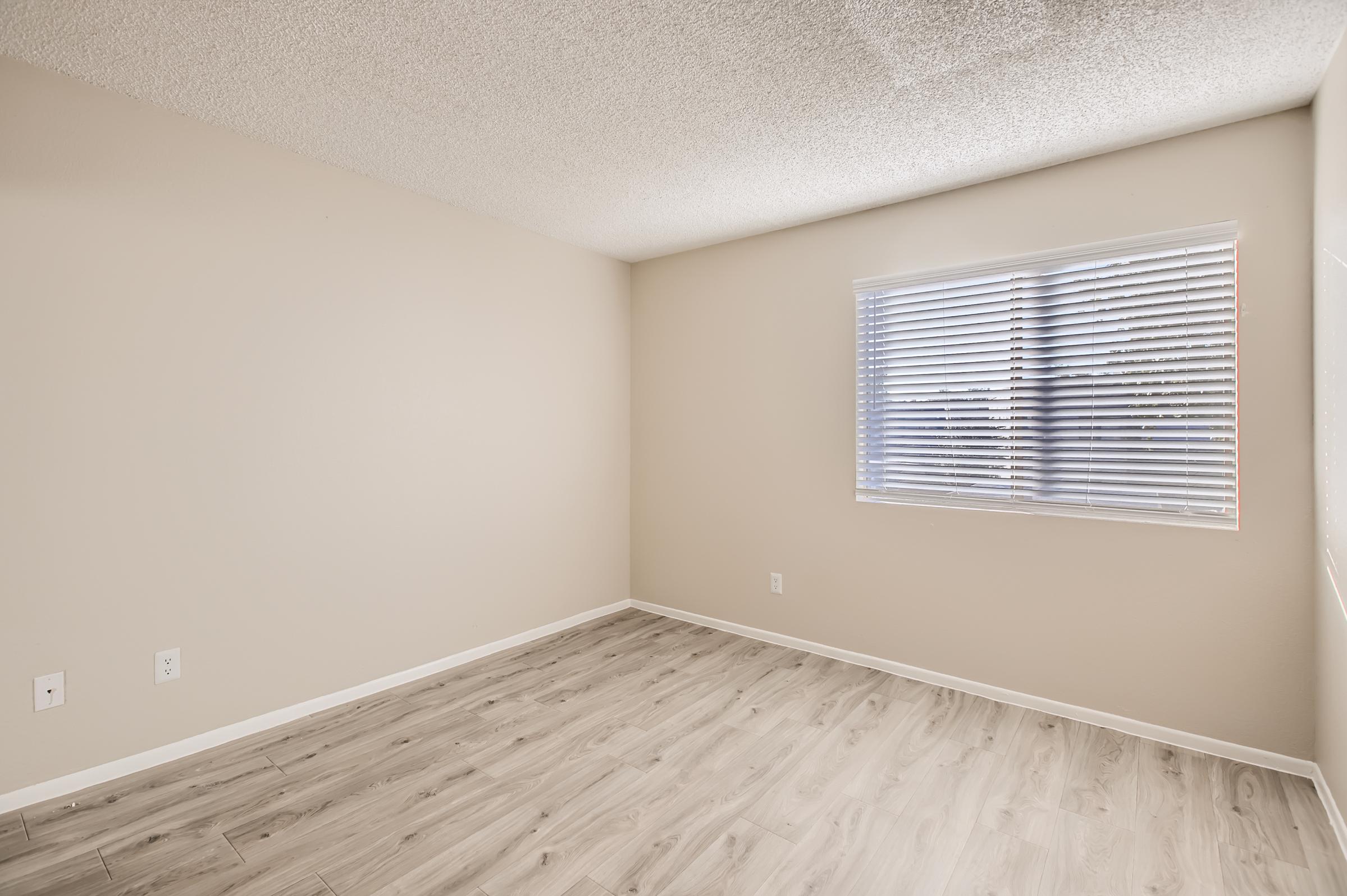 Phoenix, AZ apartment bedroom with beige walls, hardwood floors and a window