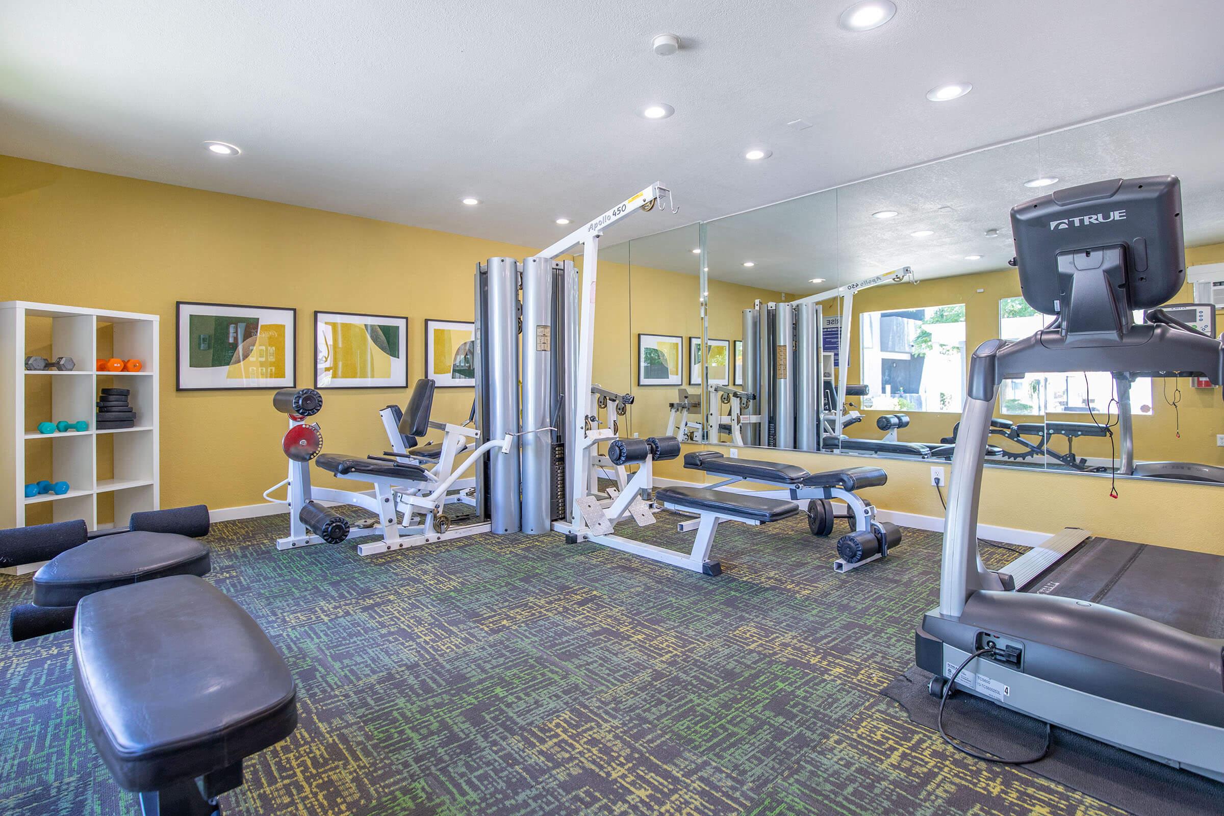 Rise Desert Cove's community yellow exercise room with workout equipment