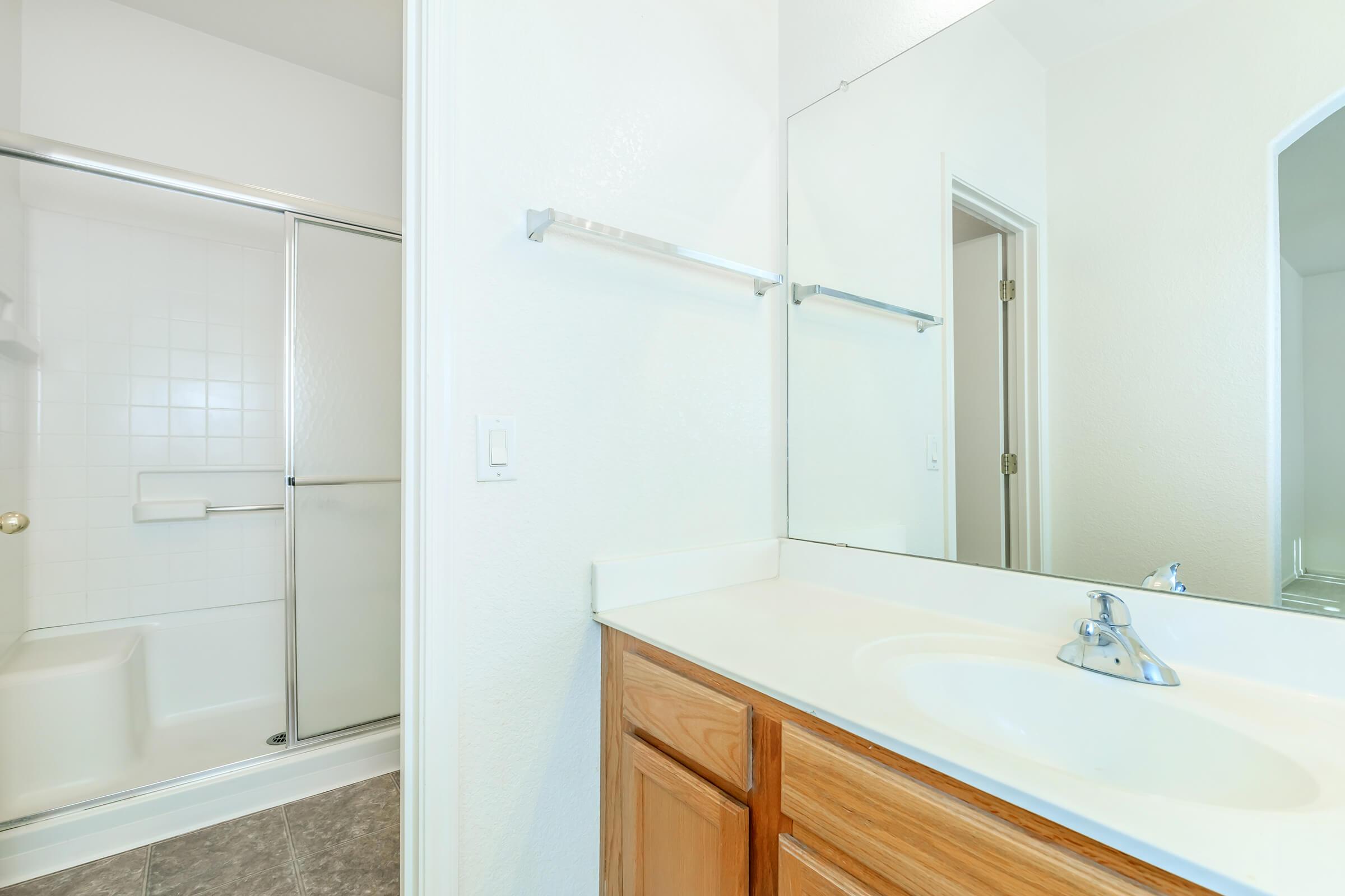 a white sink sitting under a mirror