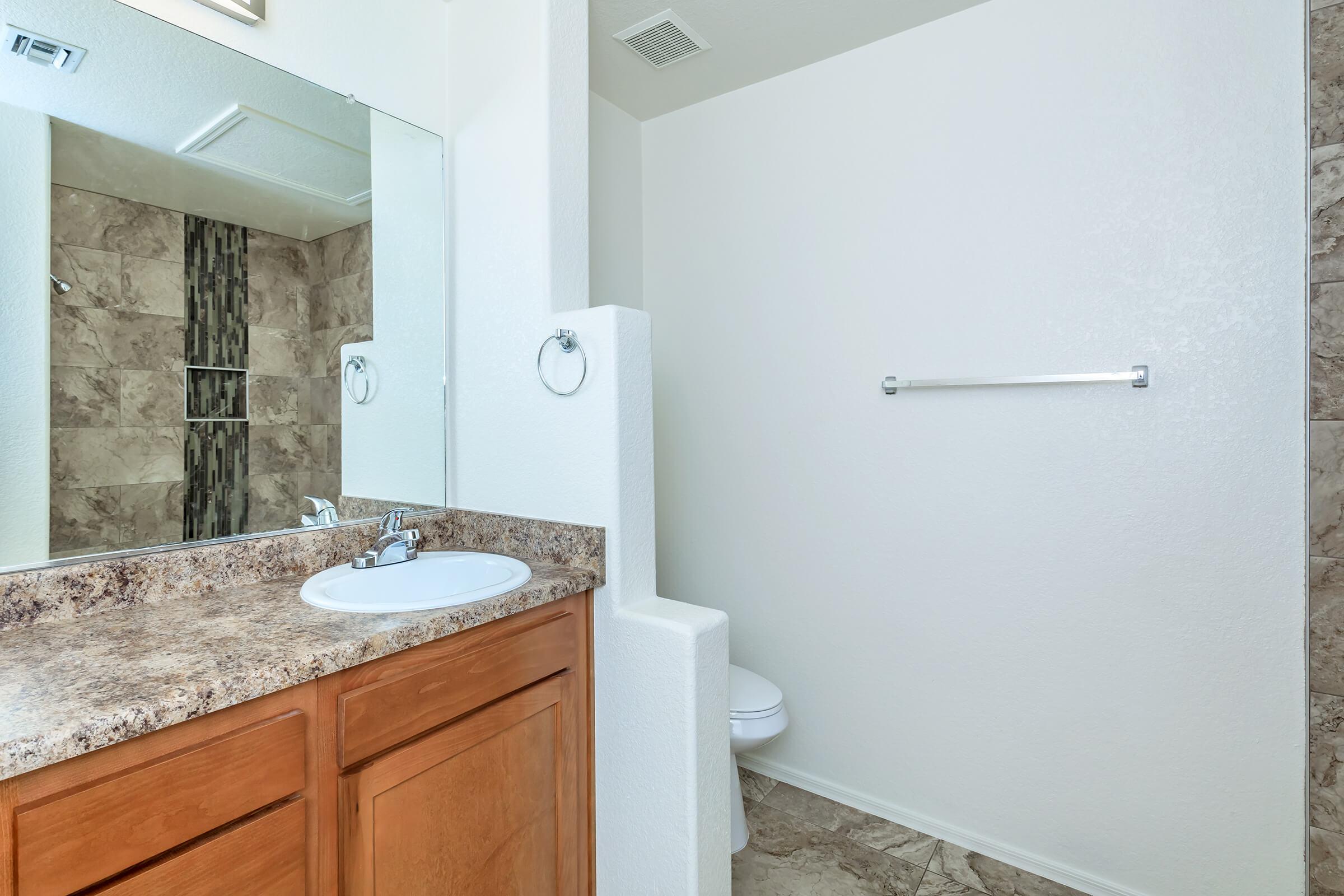 a white sink sitting under a mirror