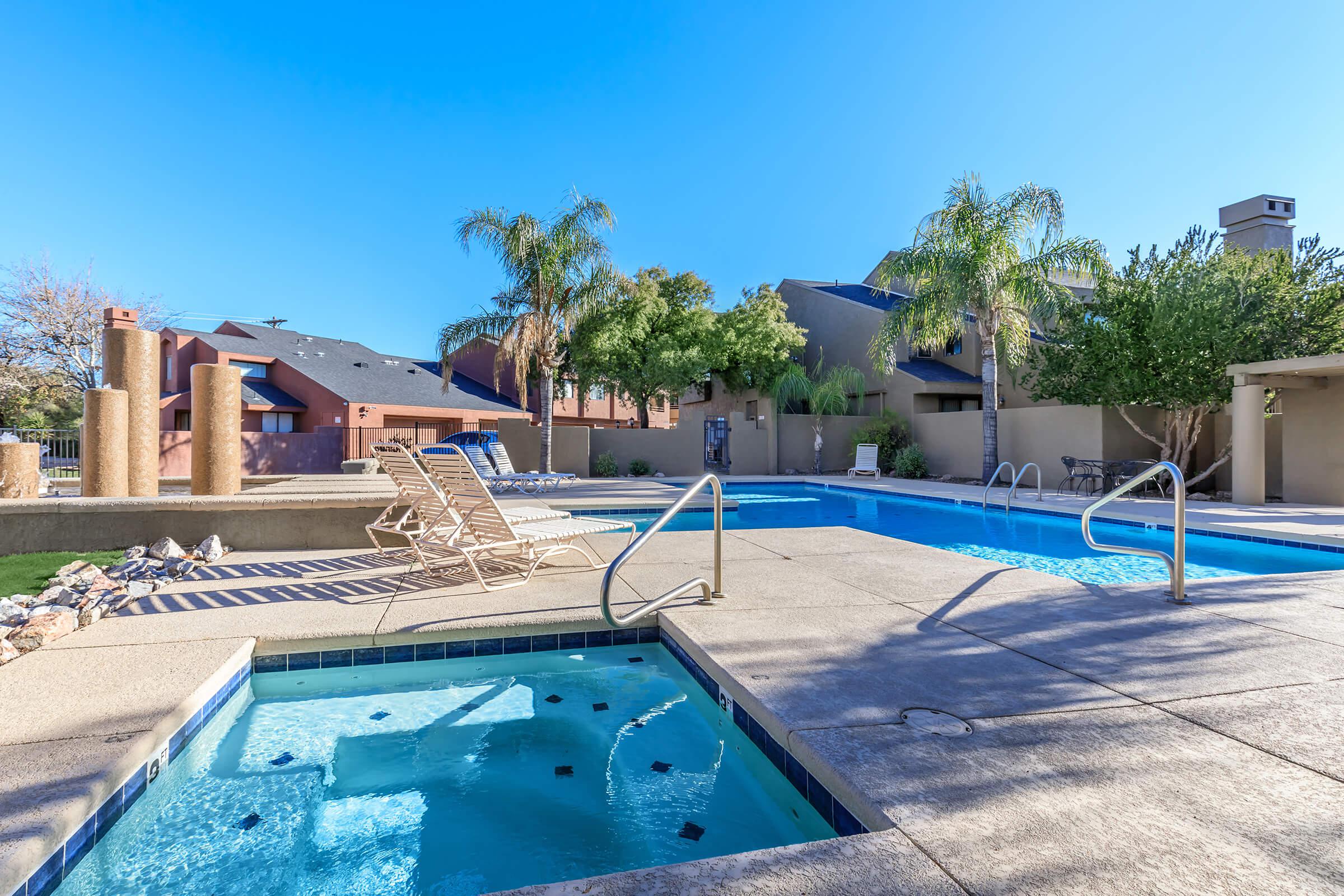 a group of palm trees next to a pool