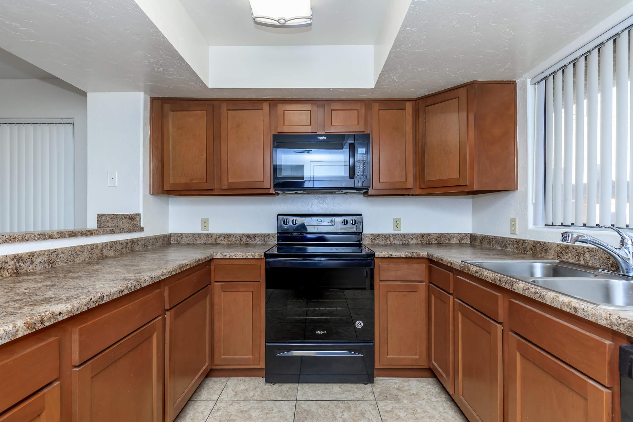 a large kitchen with stainless steel appliances and wooden cabinets