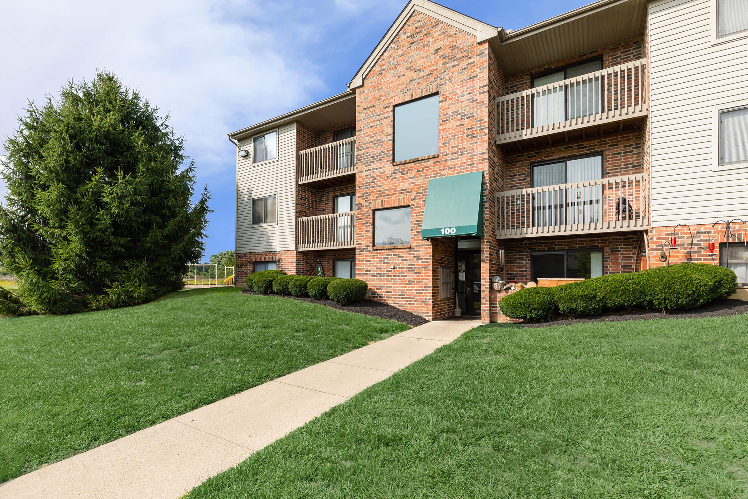 a large lawn in front of a brick building