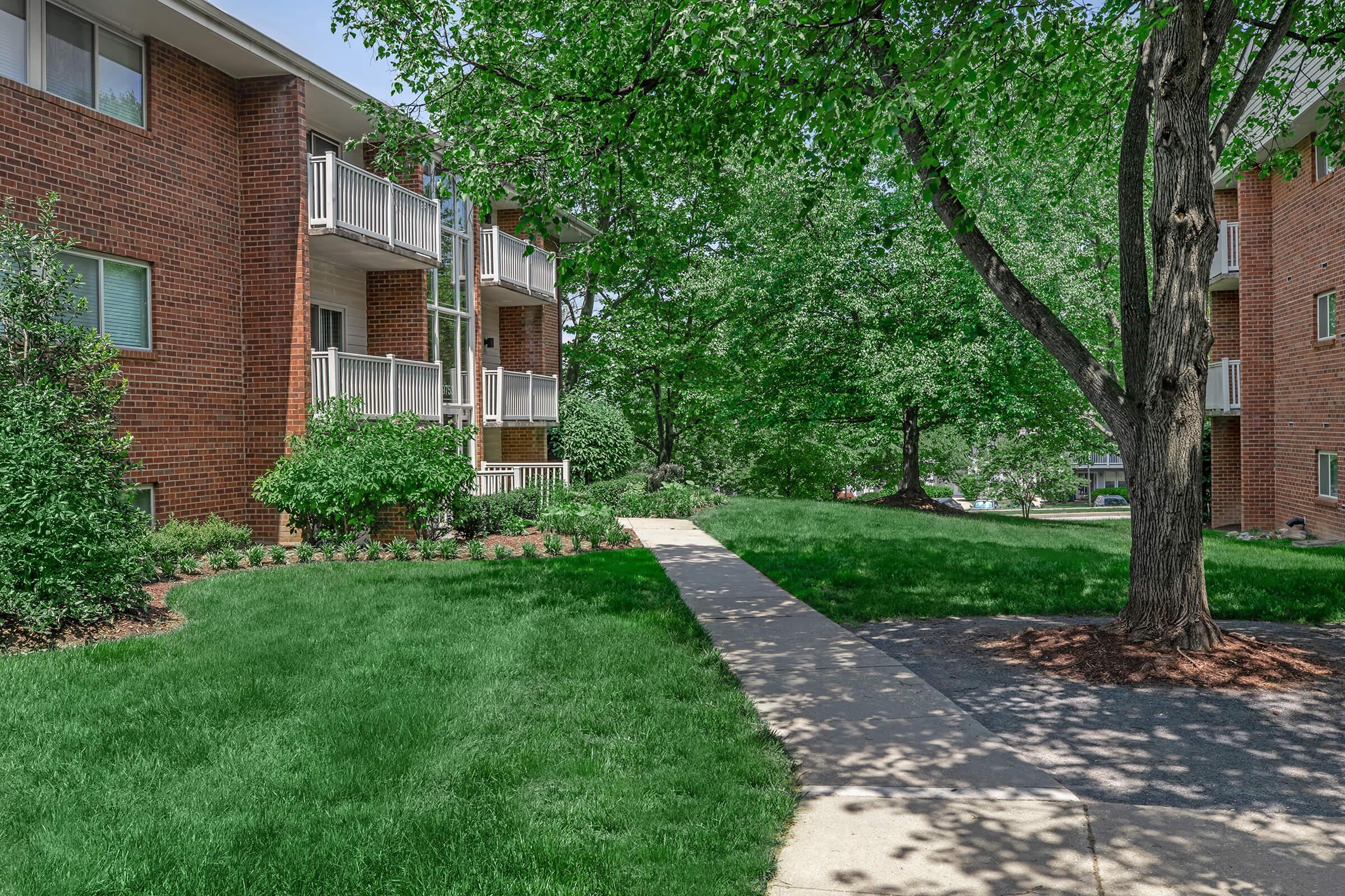 a house with a lawn in front of a brick building