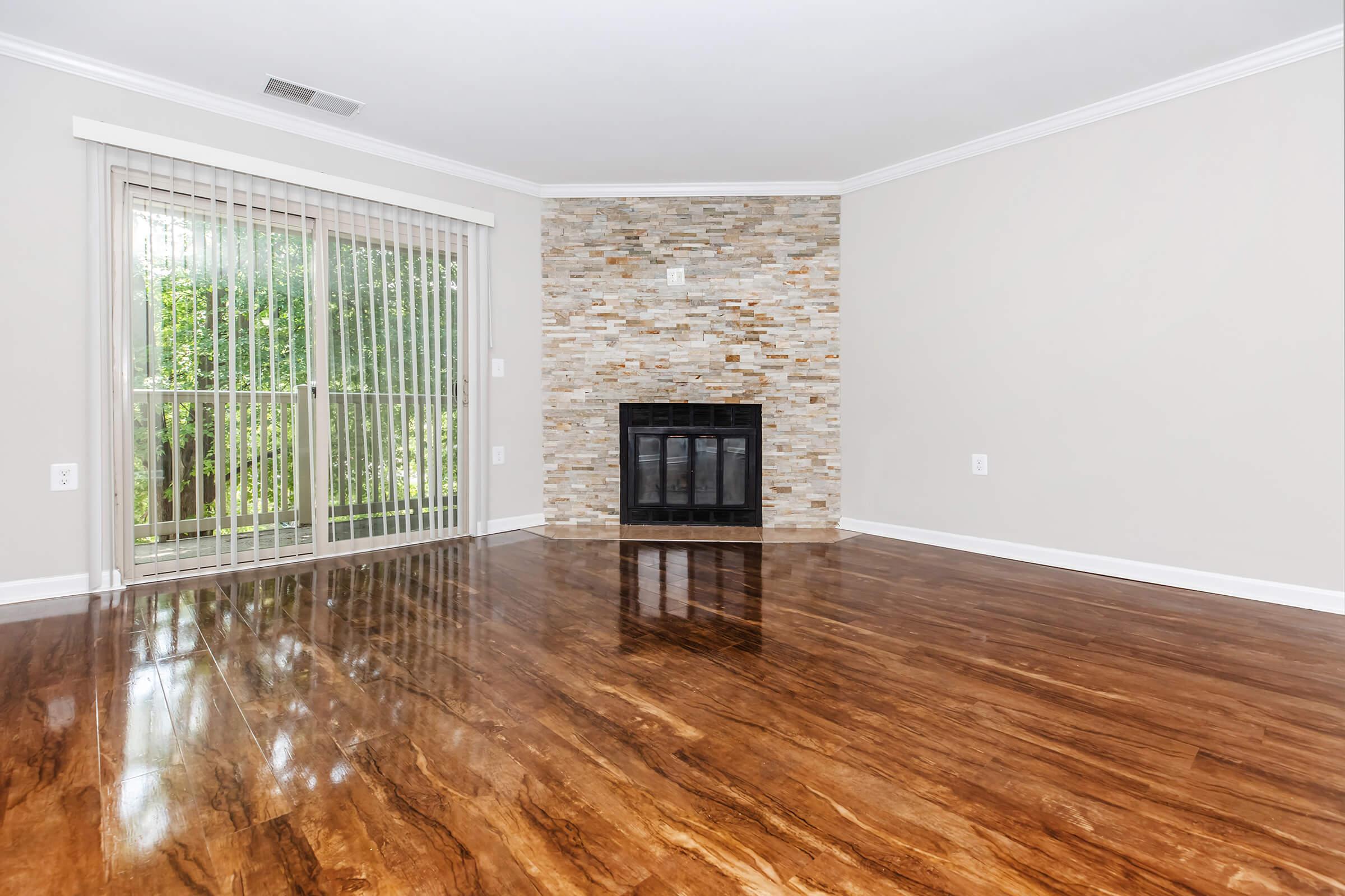 a room with wooden floors and a large window