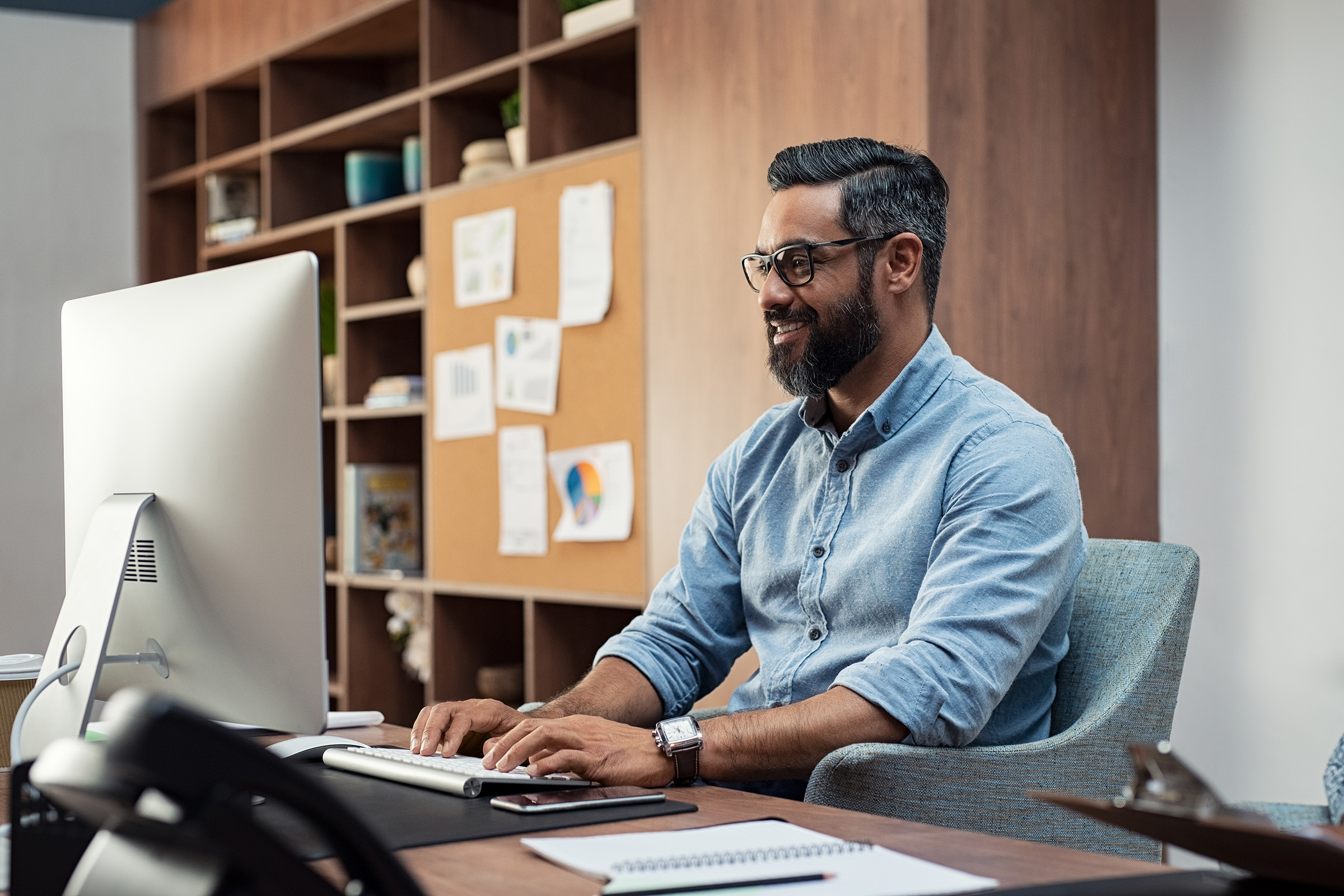 a man sitting at a desk in front of a computer