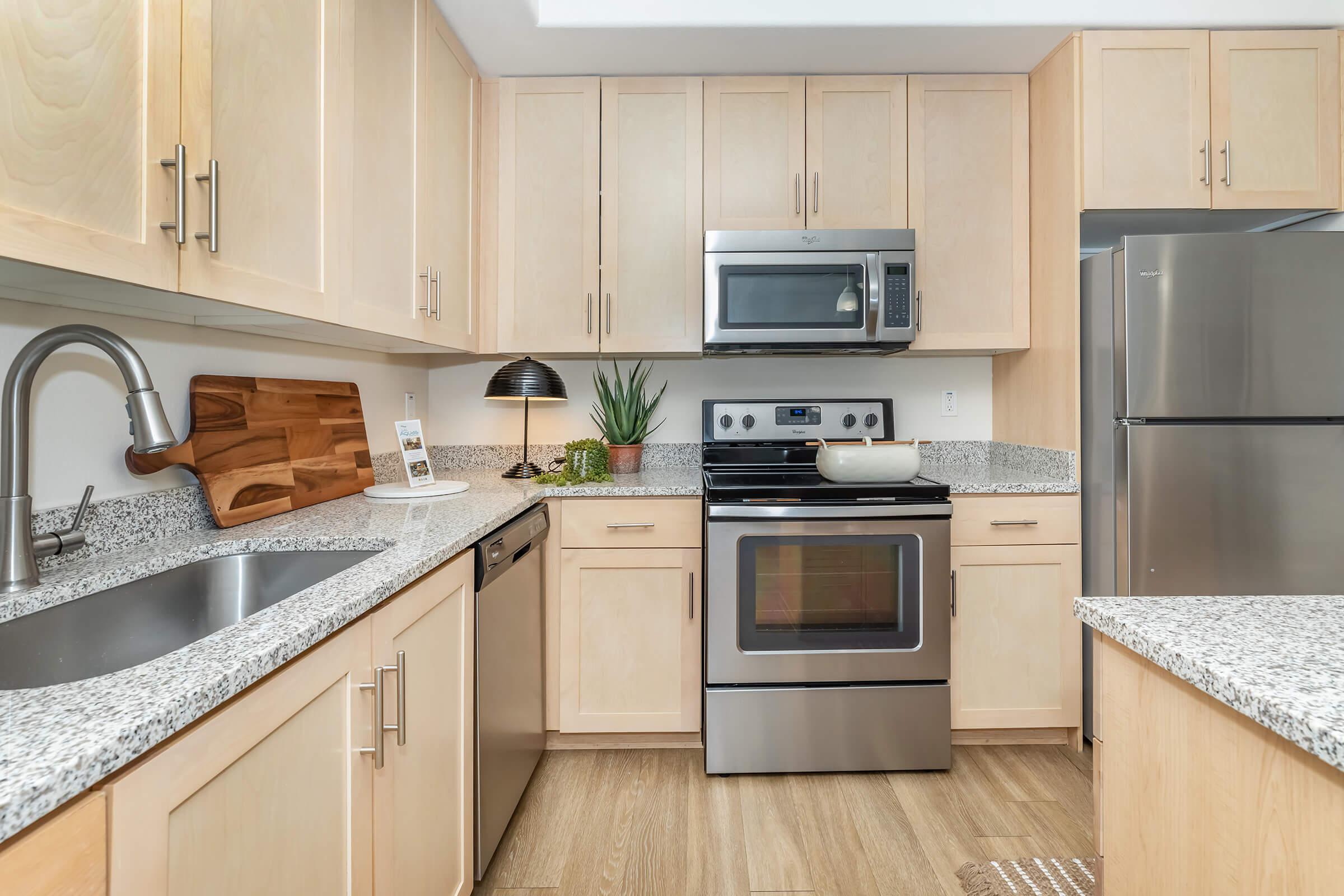 a modern kitchen with stainless steel appliances and wooden cabinets