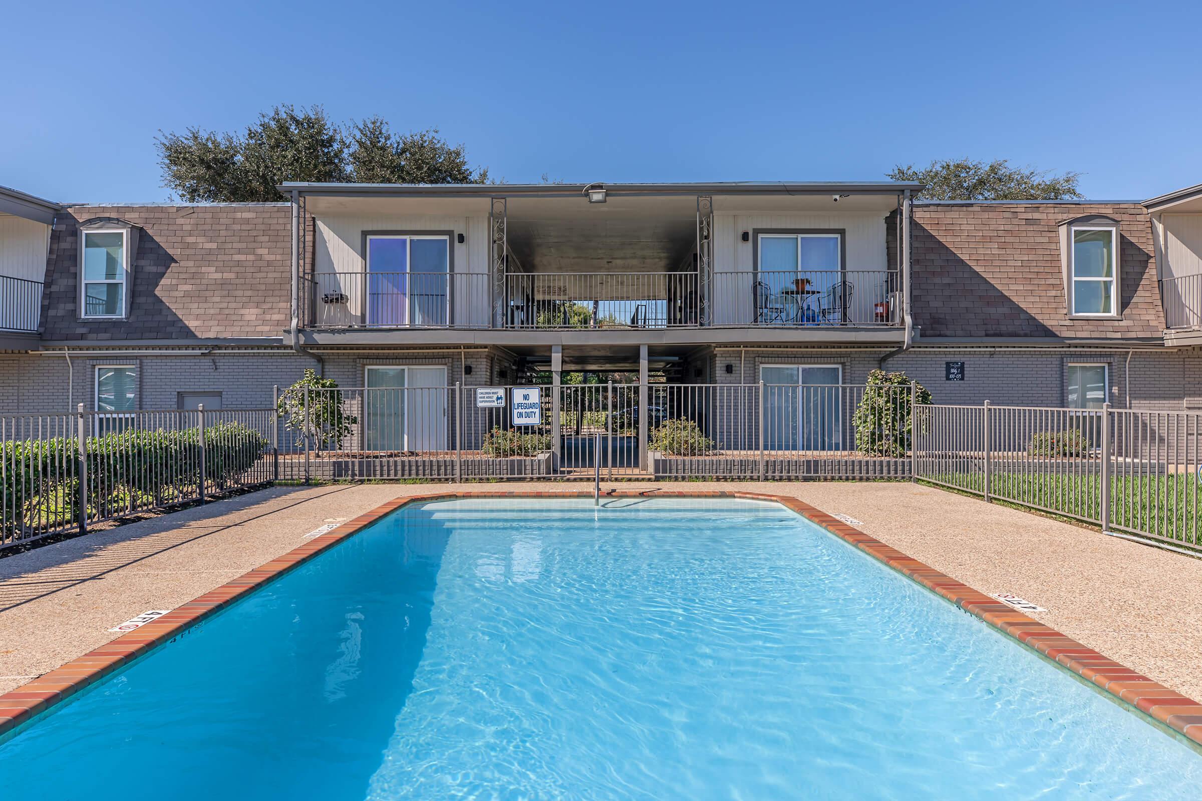 a house with a pool in front of a building