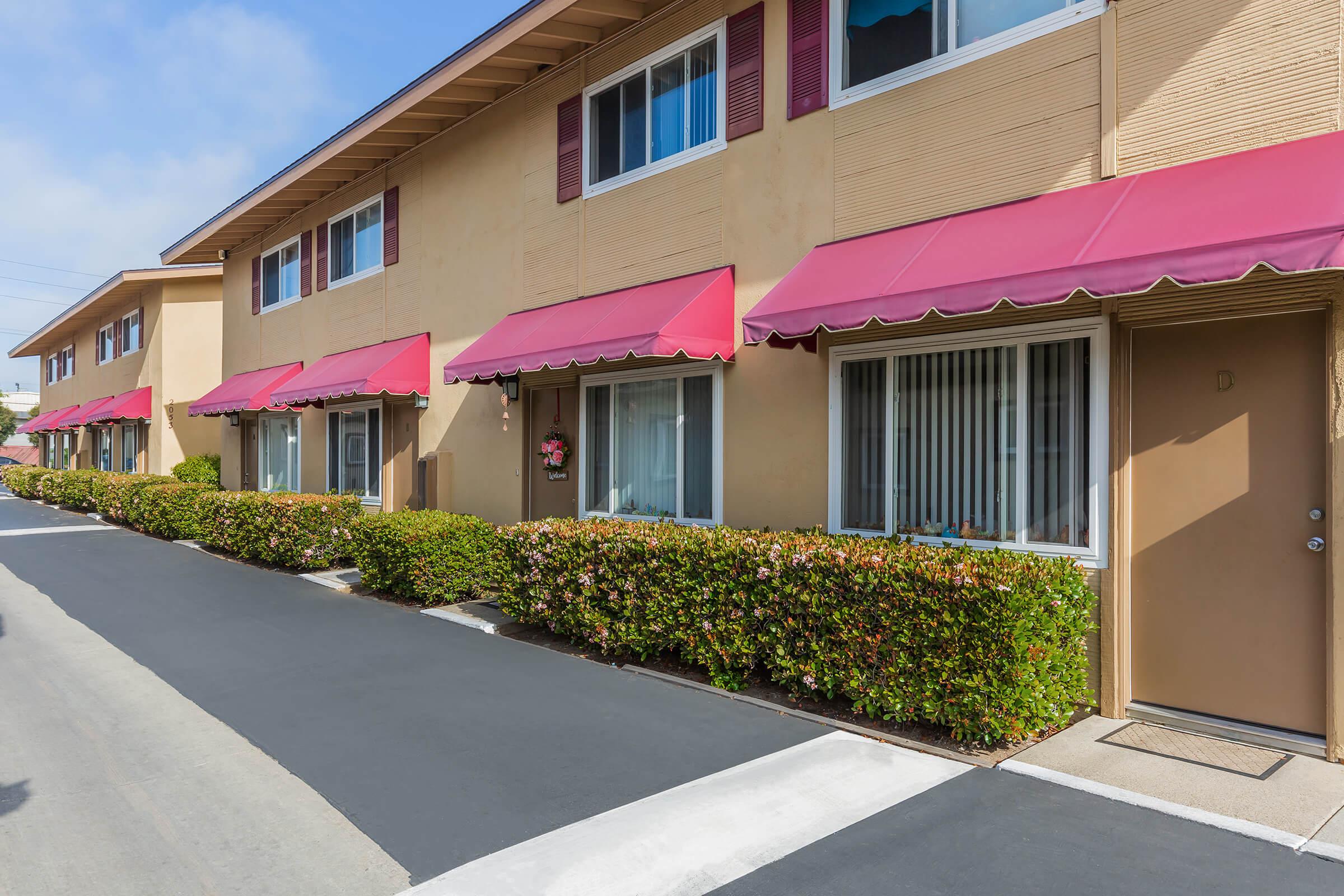 Woodhaven Townhomes community building with green shrubs