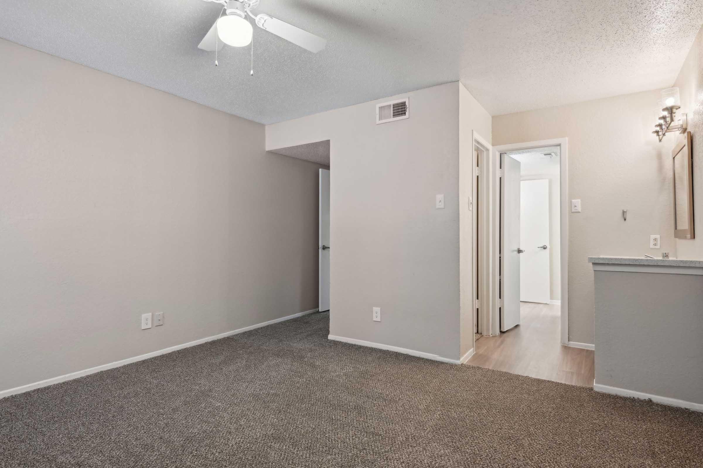 a large empty room with a sink and a mirror