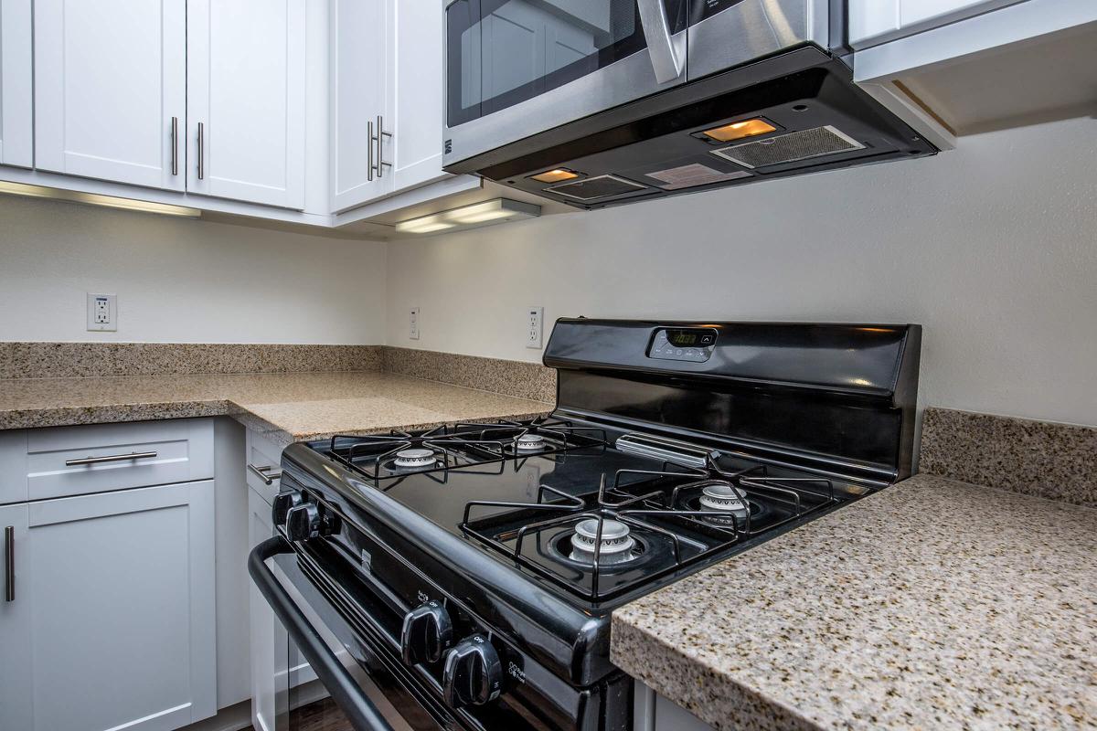 a stove top oven sitting inside of a kitchen