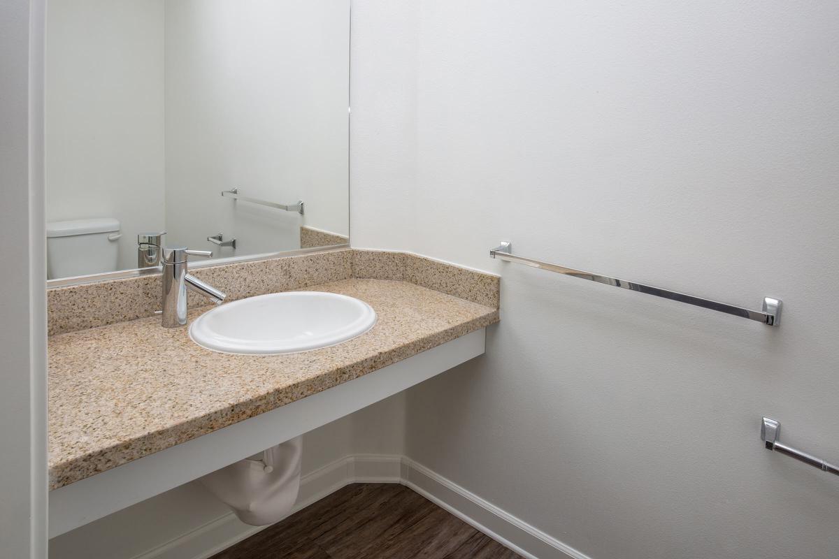 a white sink sitting under a mirror