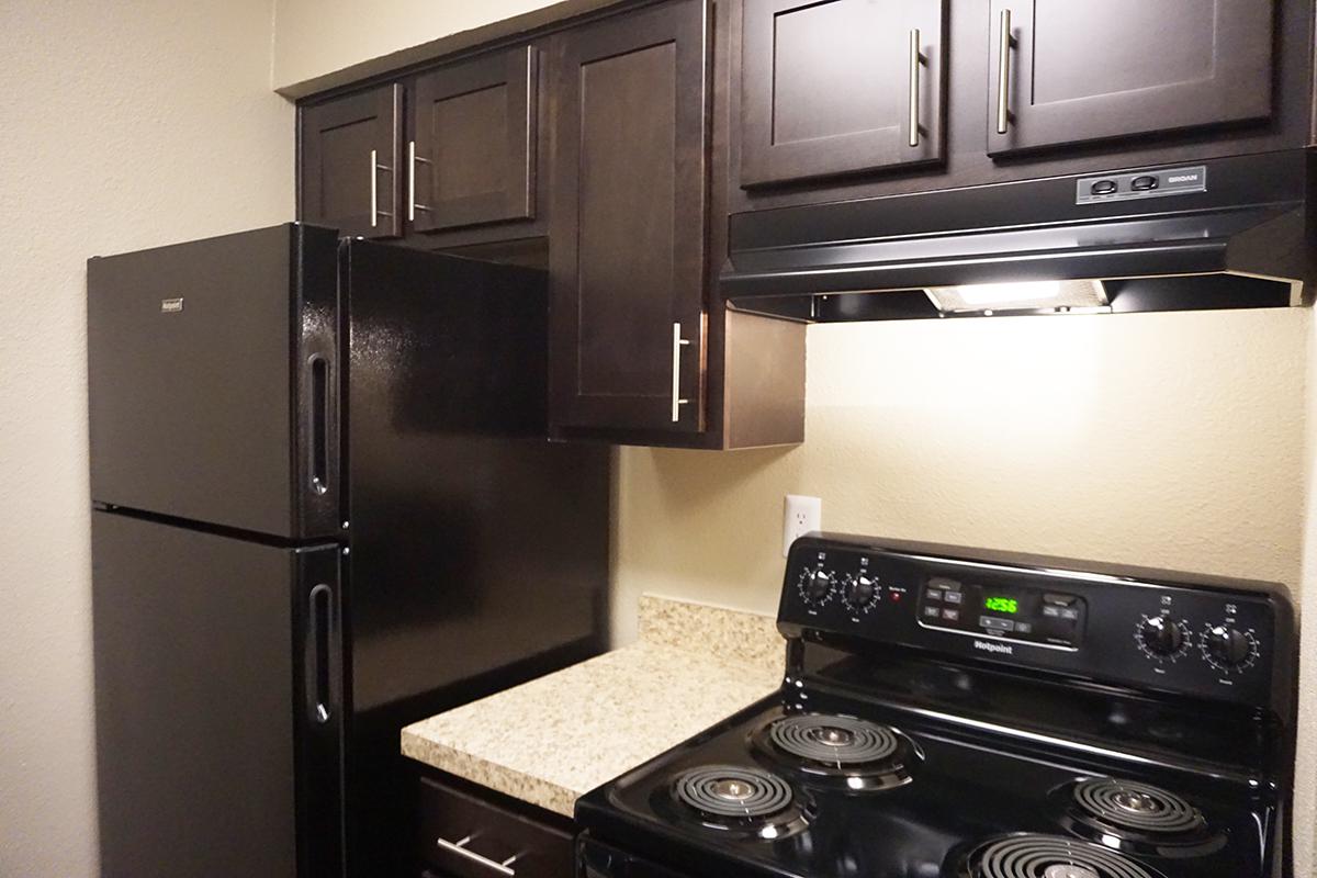 a black stove top oven sitting inside of a kitchen with stainless steel appliances