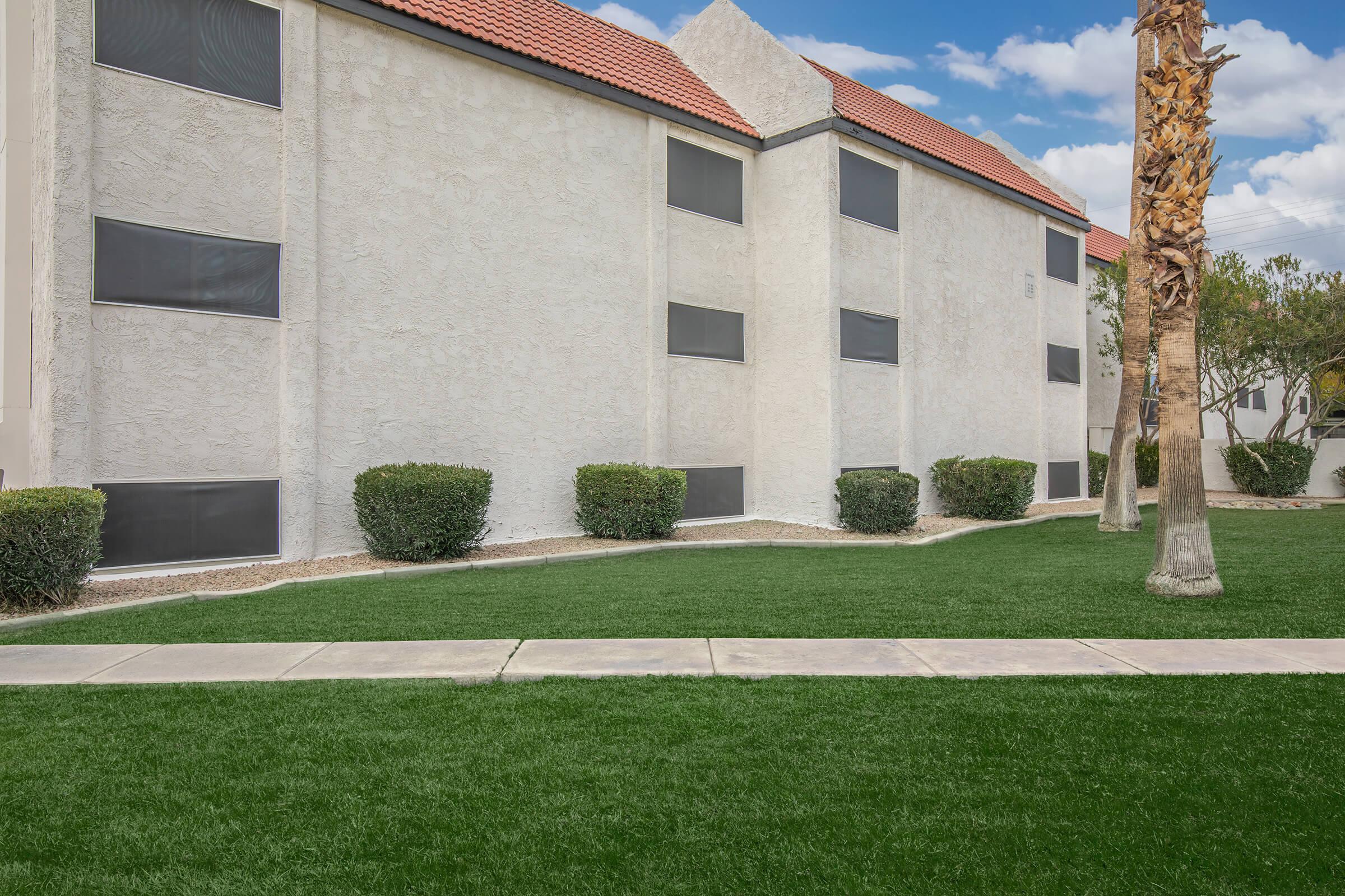 a large lawn in front of a brick building