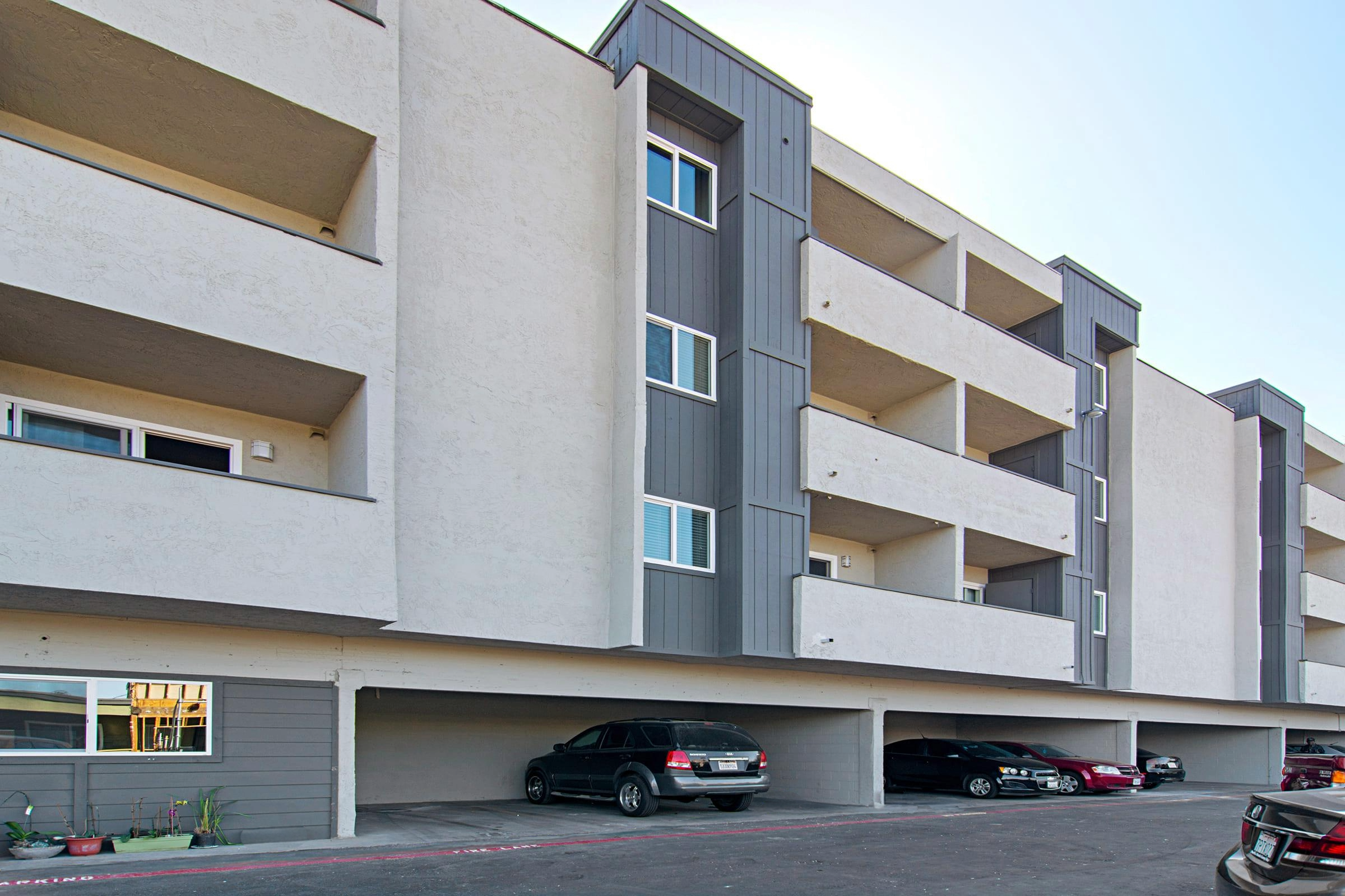 Close up view of apartment building with cars parked in carports
