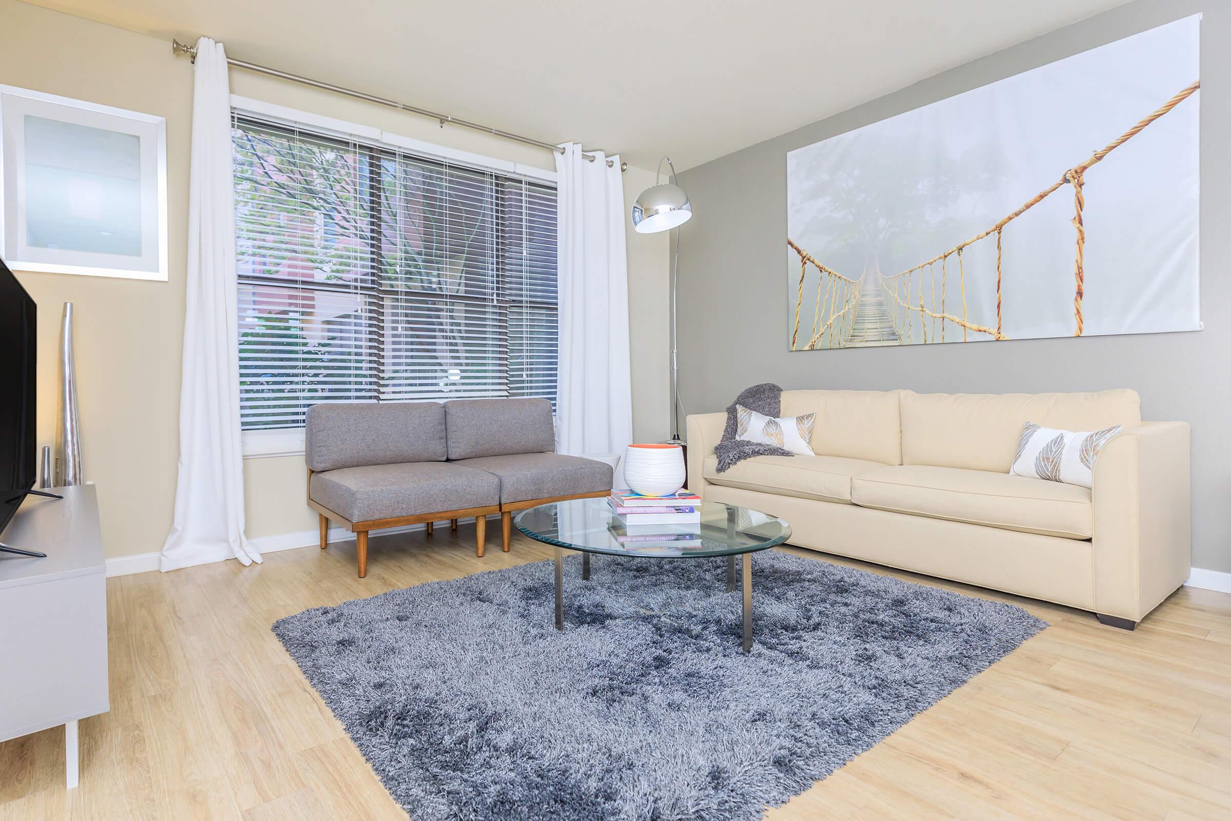 a living room filled with furniture and a large window