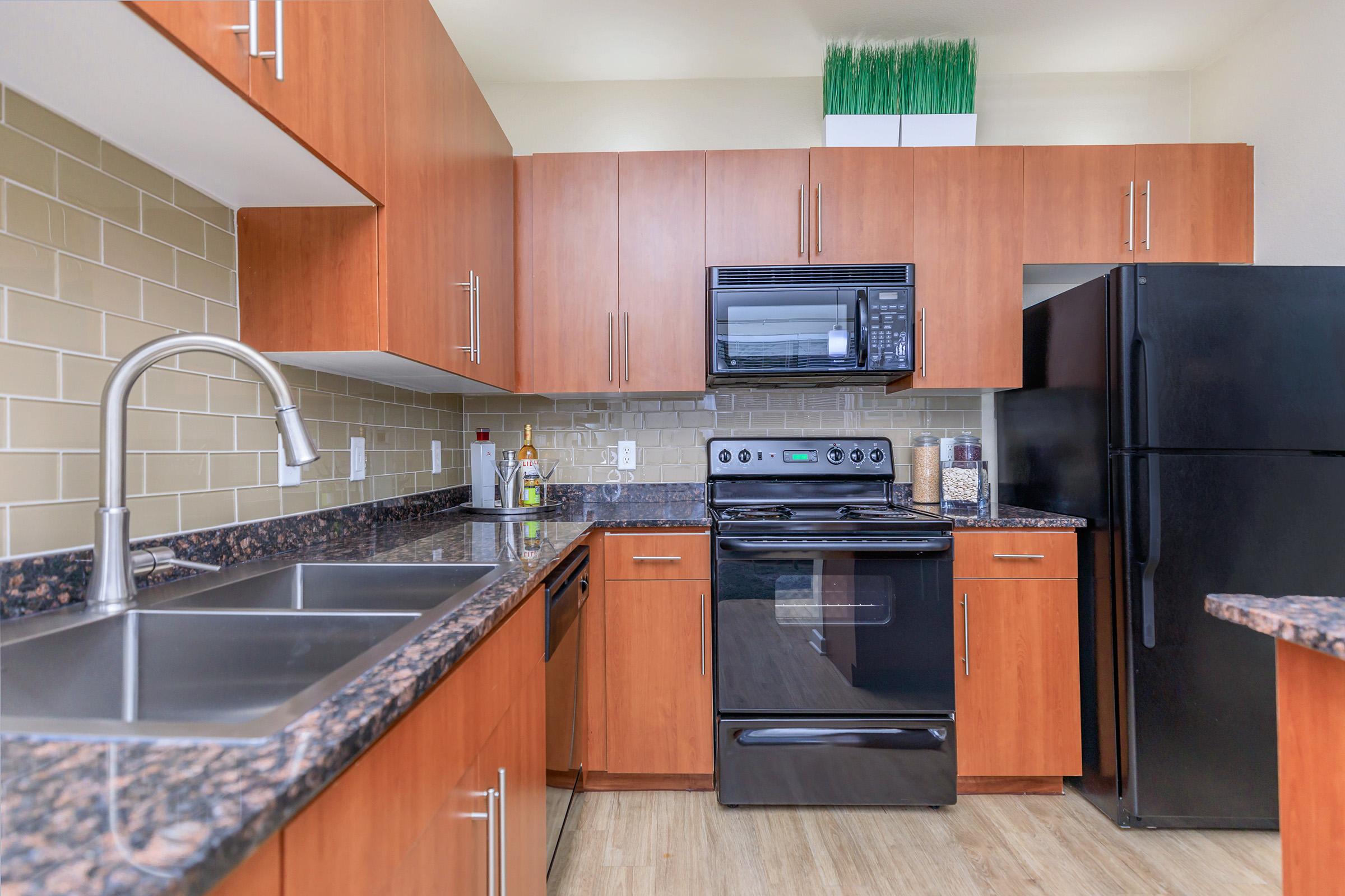 a large kitchen with stainless steel appliances and wooden cabinets