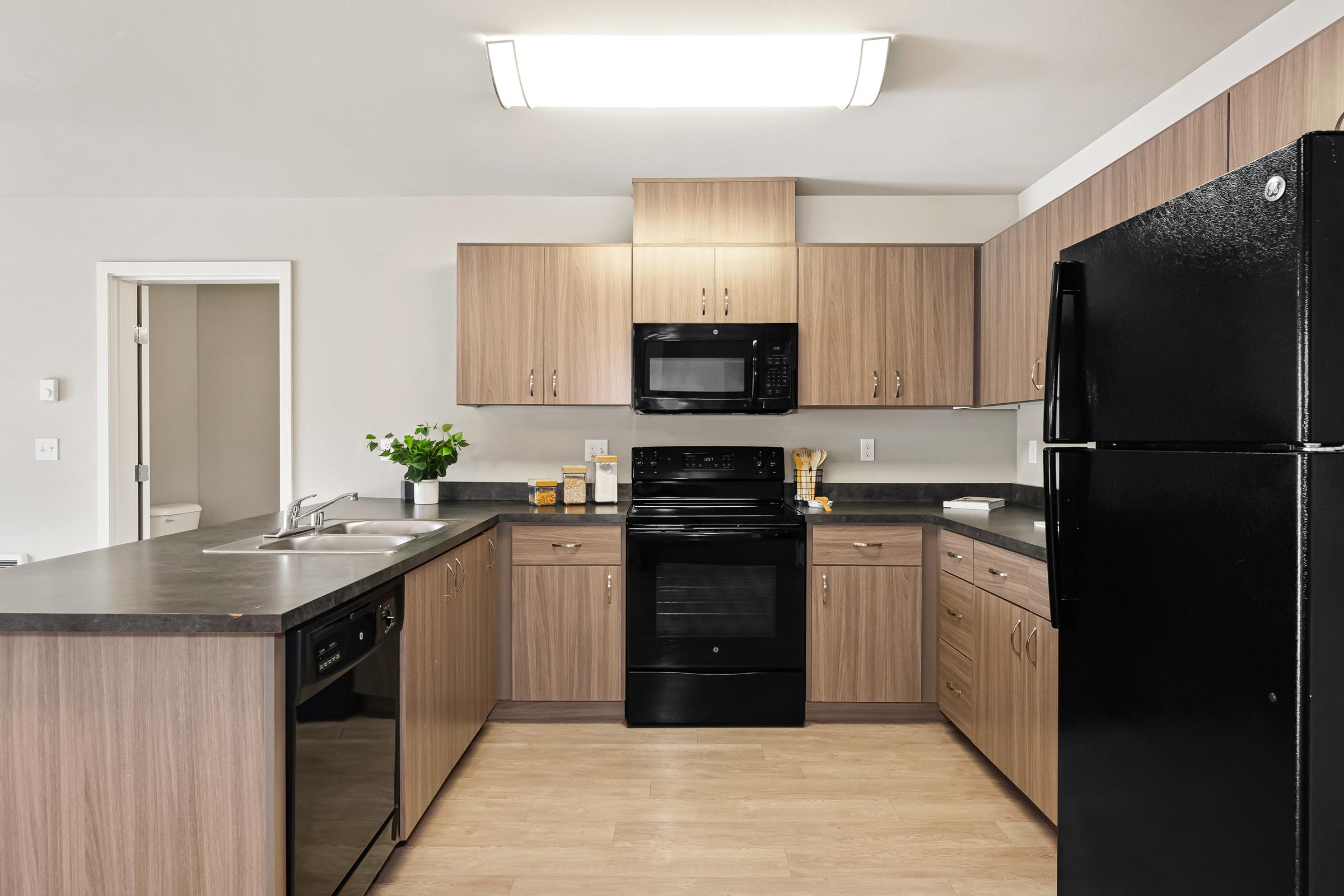 a modern kitchen with stainless steel appliances and wooden cabinets