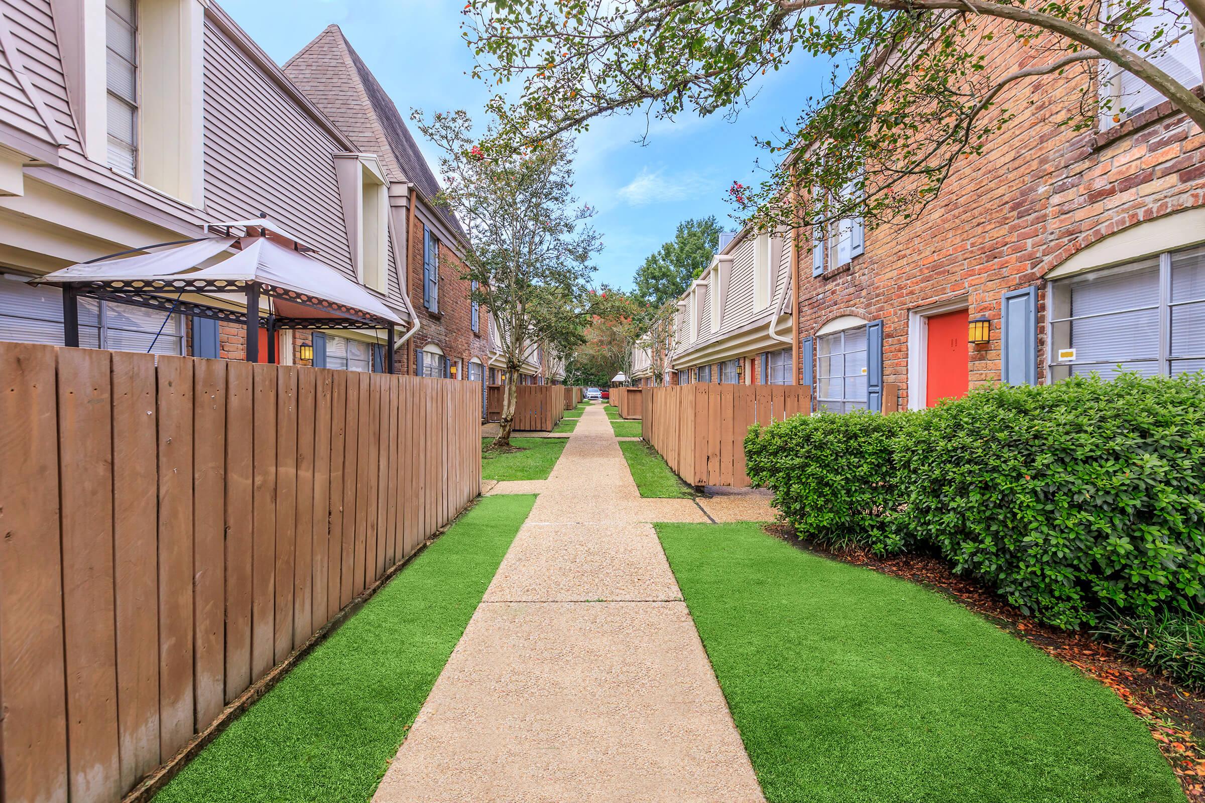 a path with trees on the side of a building