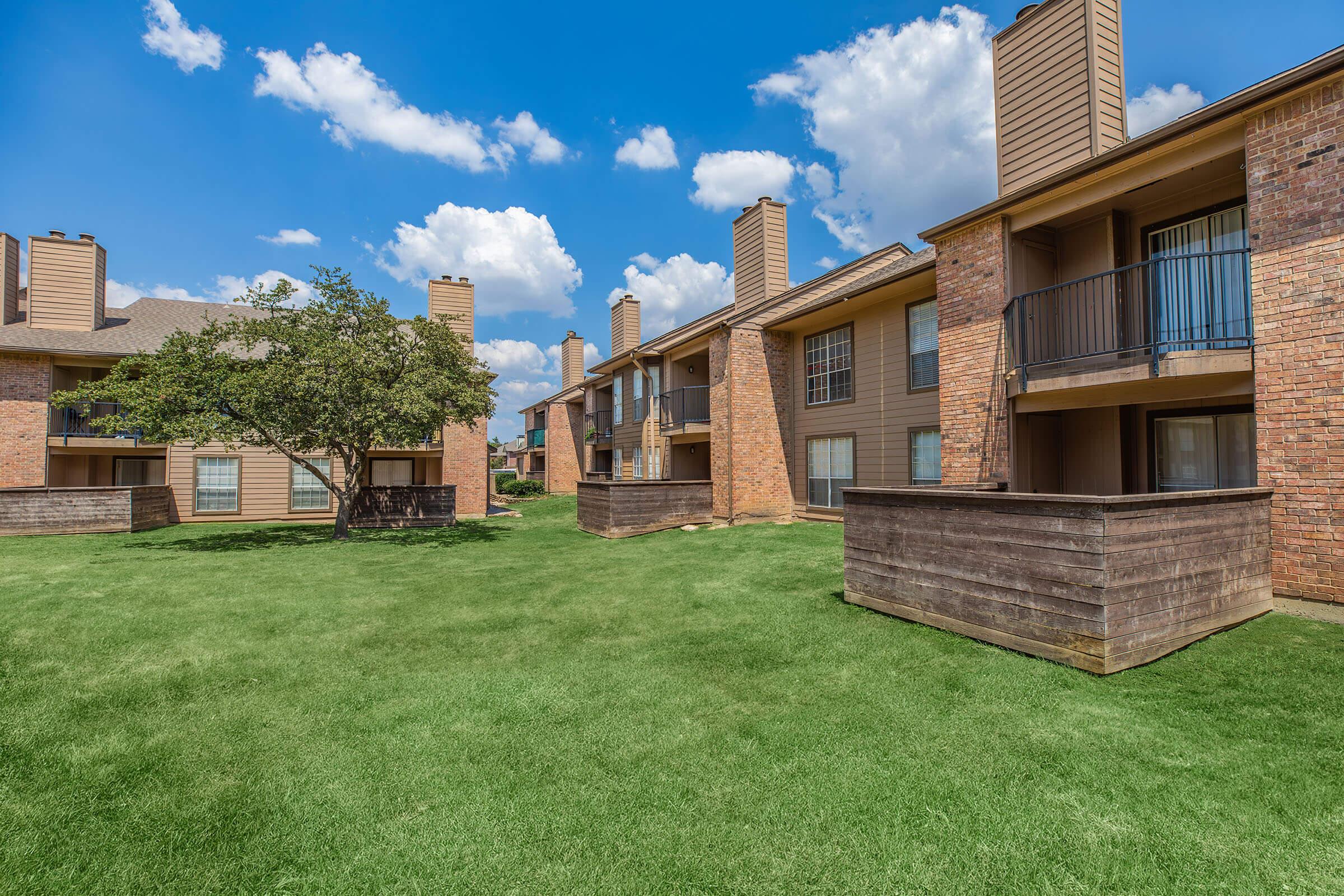 a large lawn in front of a brick building