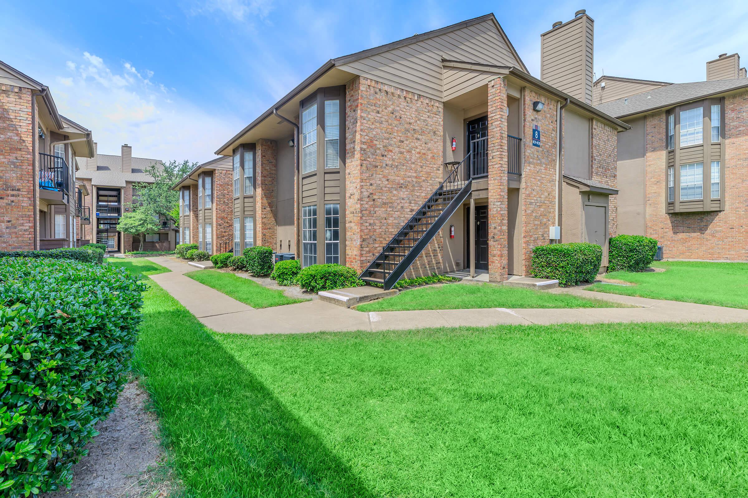 a large lawn in front of a brick building