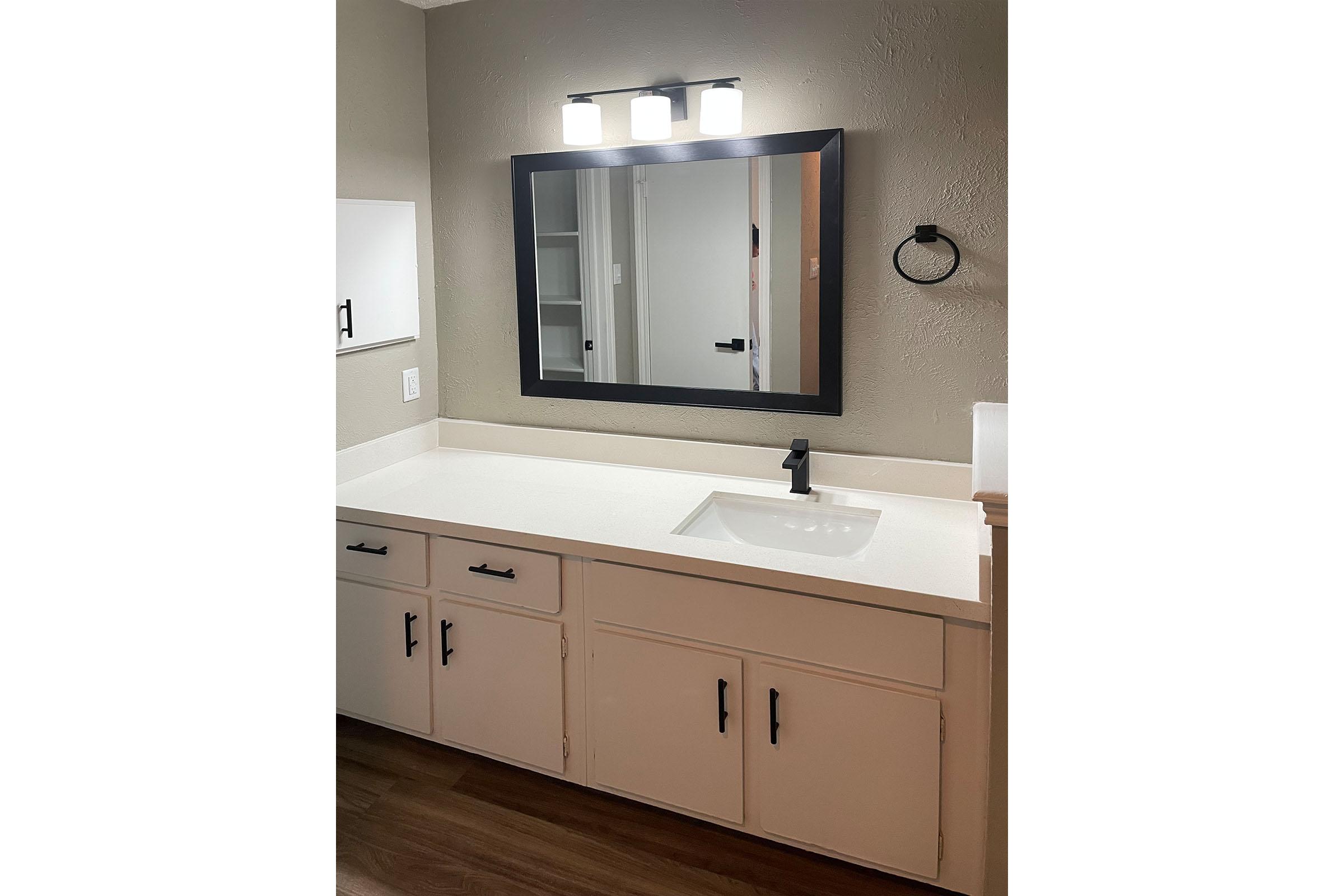 a kitchen with a sink and a mirror