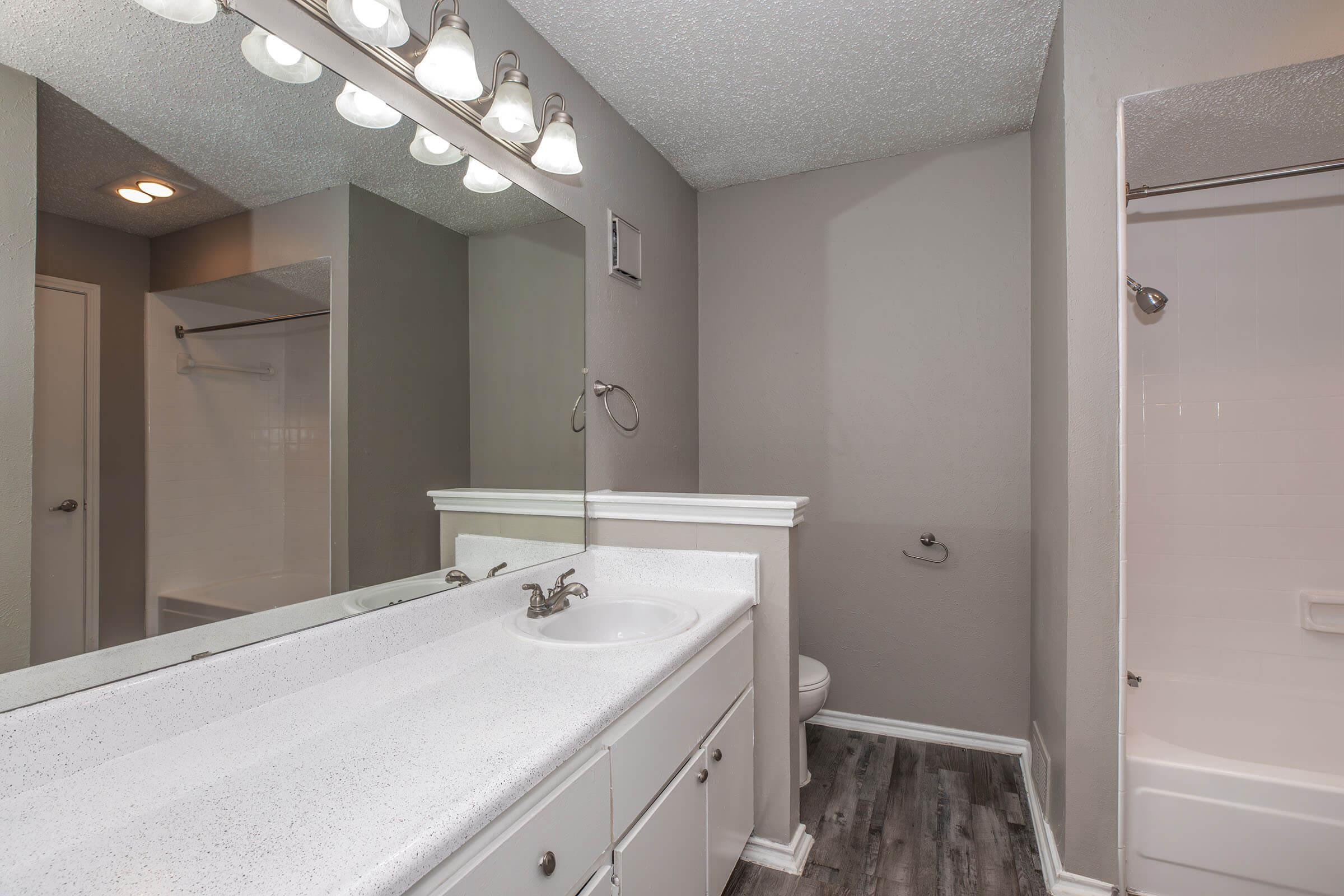 a bedroom area with a sink and a mirror