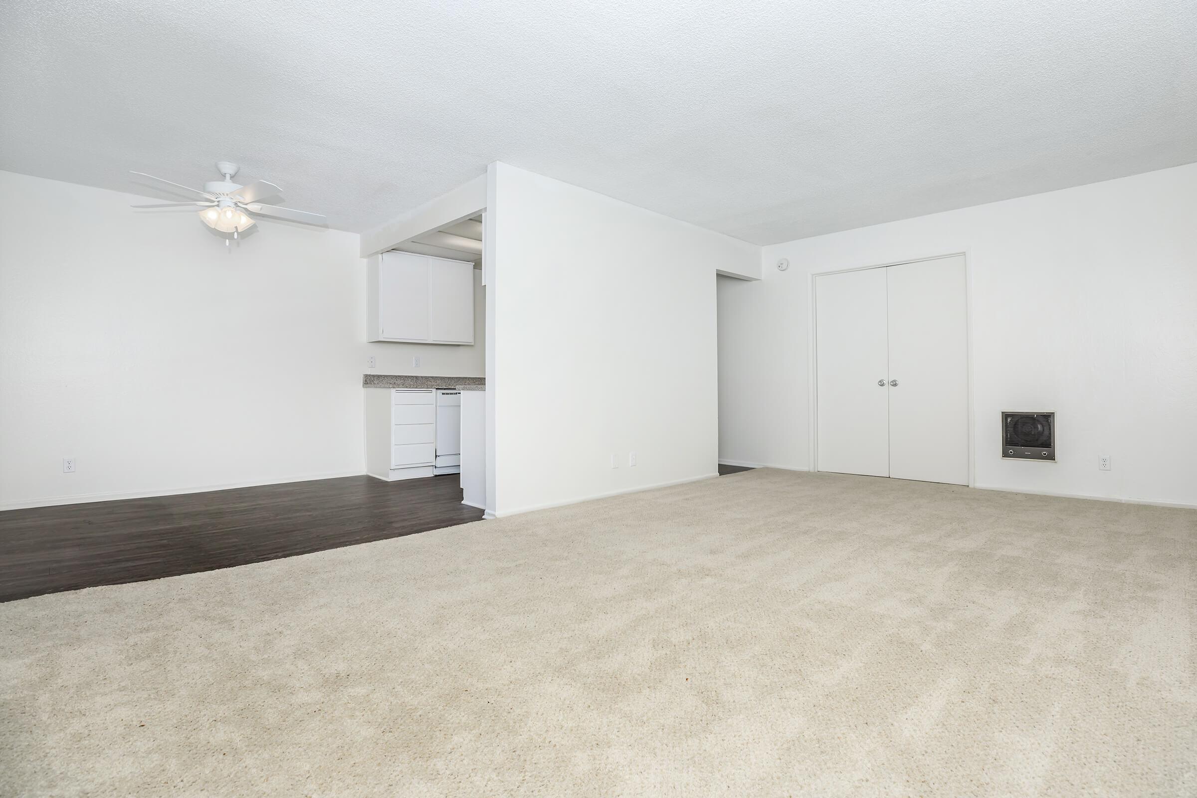 Unfurnished living room with carpet and wooden floored dining room