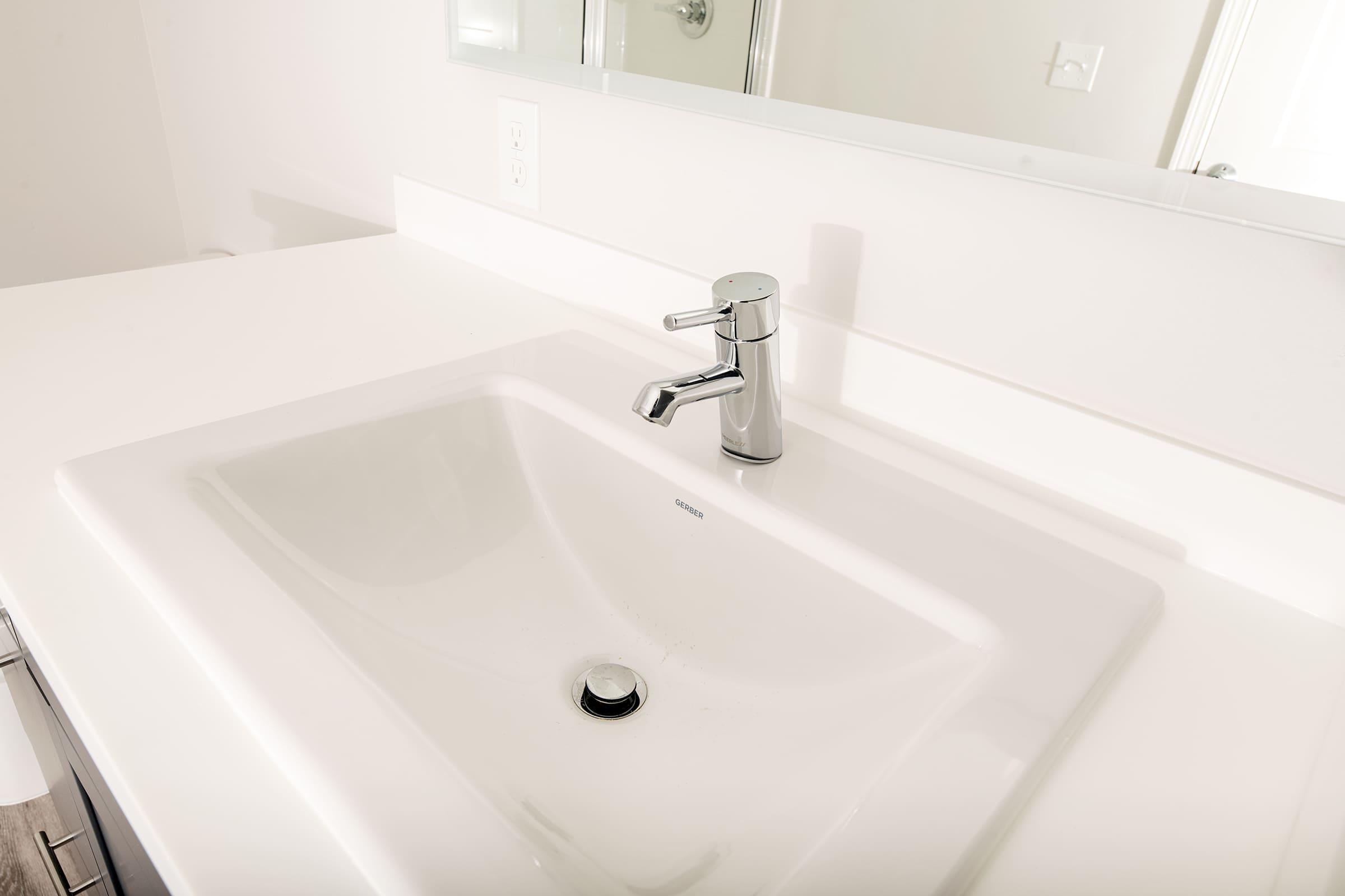 a sink sitting under a mirror