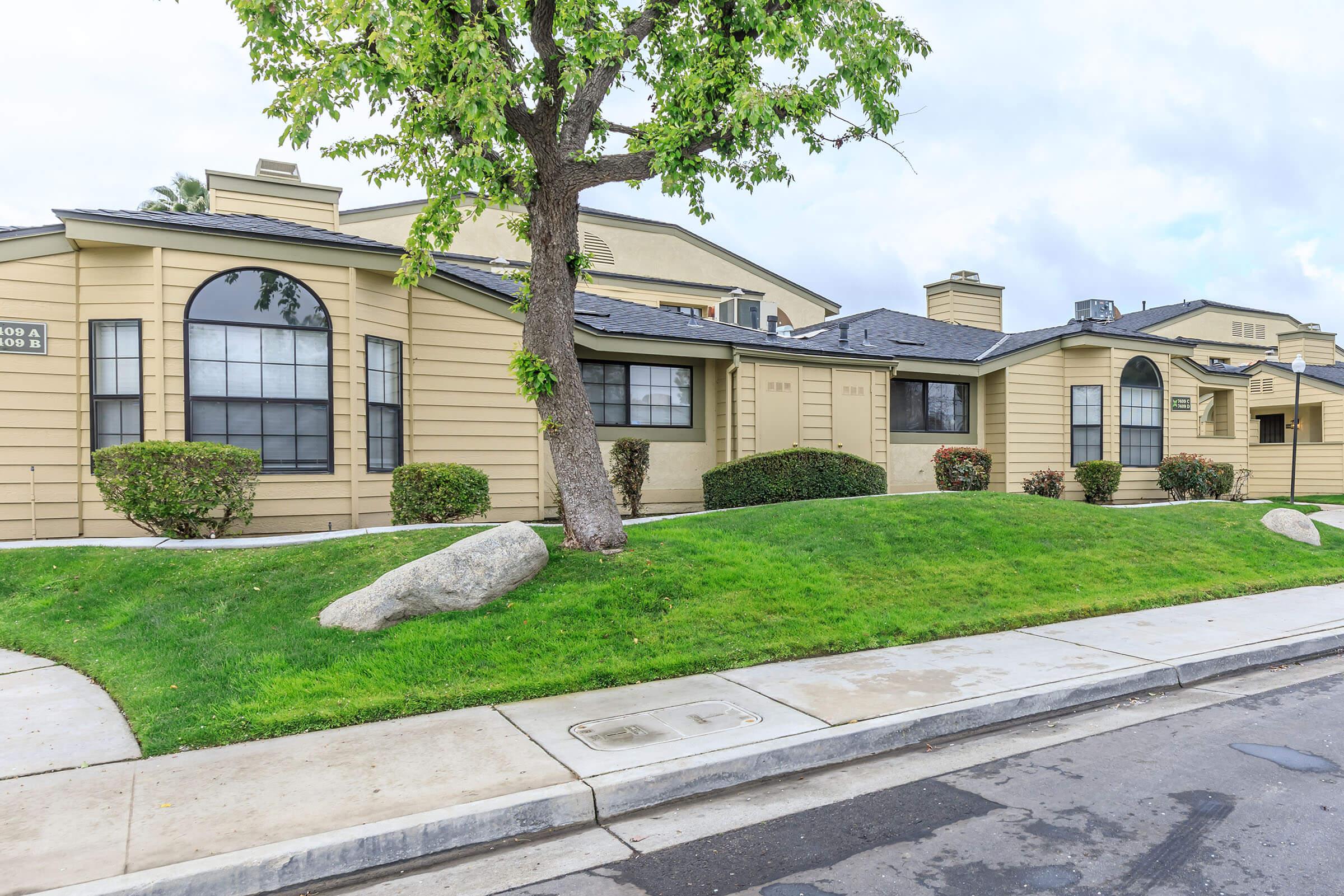 a large brick building with grass in front of a house