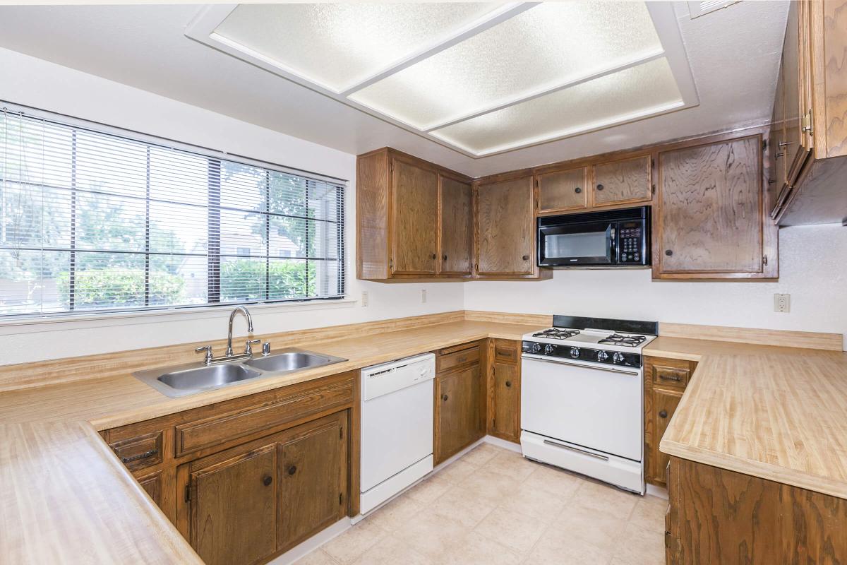 a large kitchen with stainless steel appliances and wooden cabinets