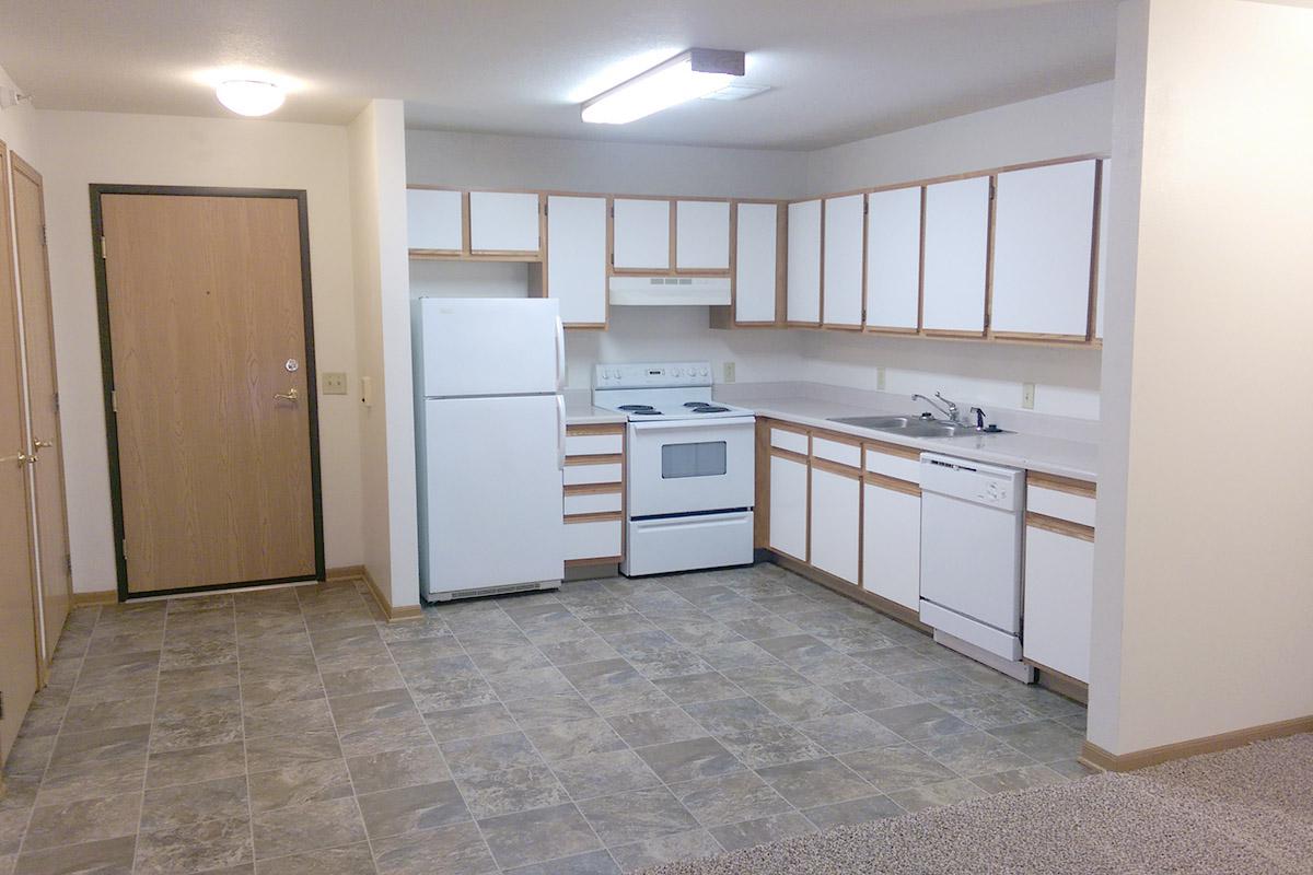 a kitchen with white cabinets and a wood floor