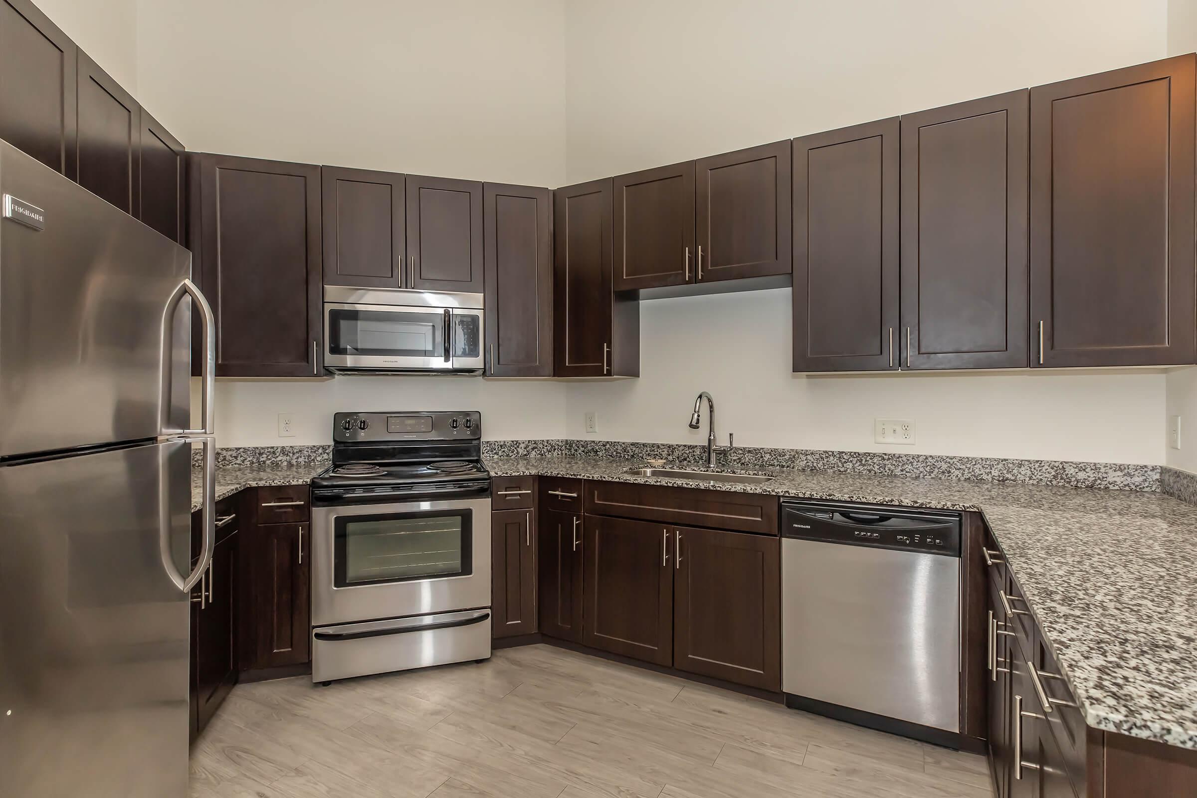 a large kitchen with stainless steel appliances and wooden cabinets