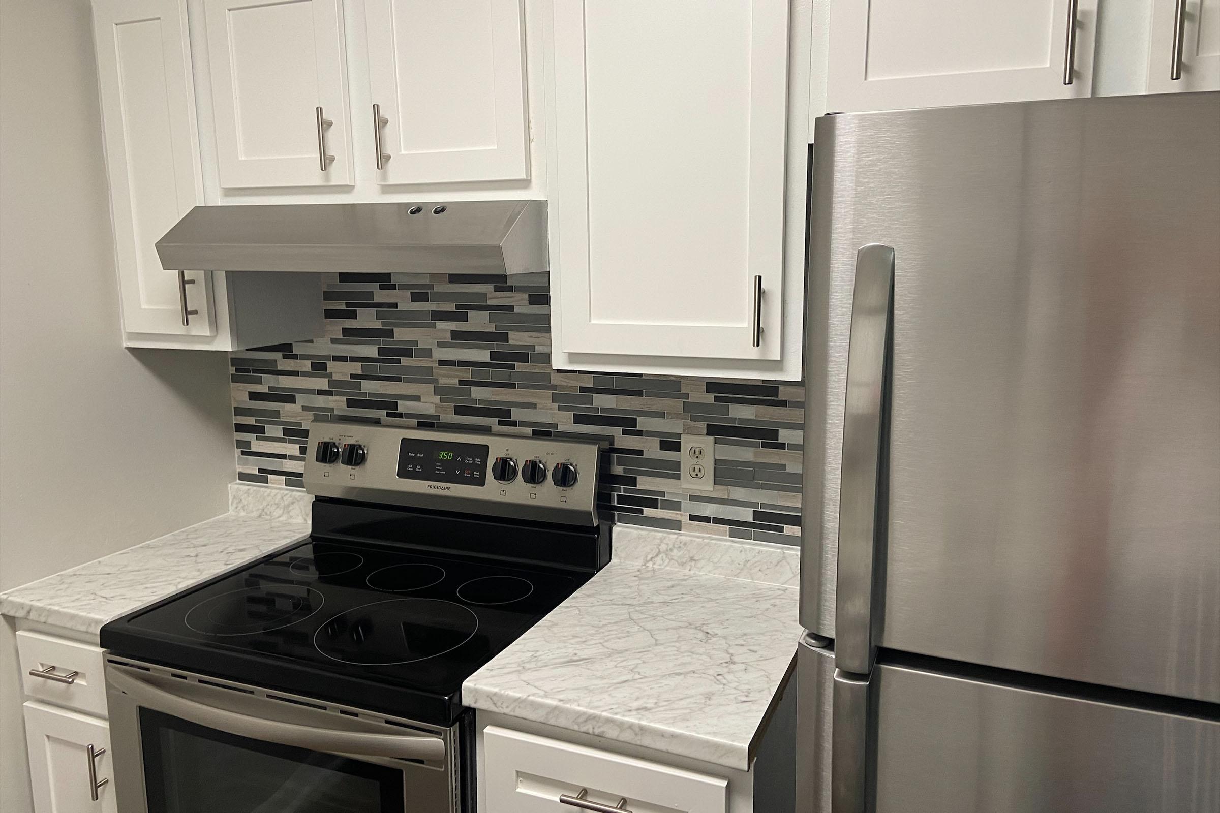 a stove top oven sitting inside of a kitchen