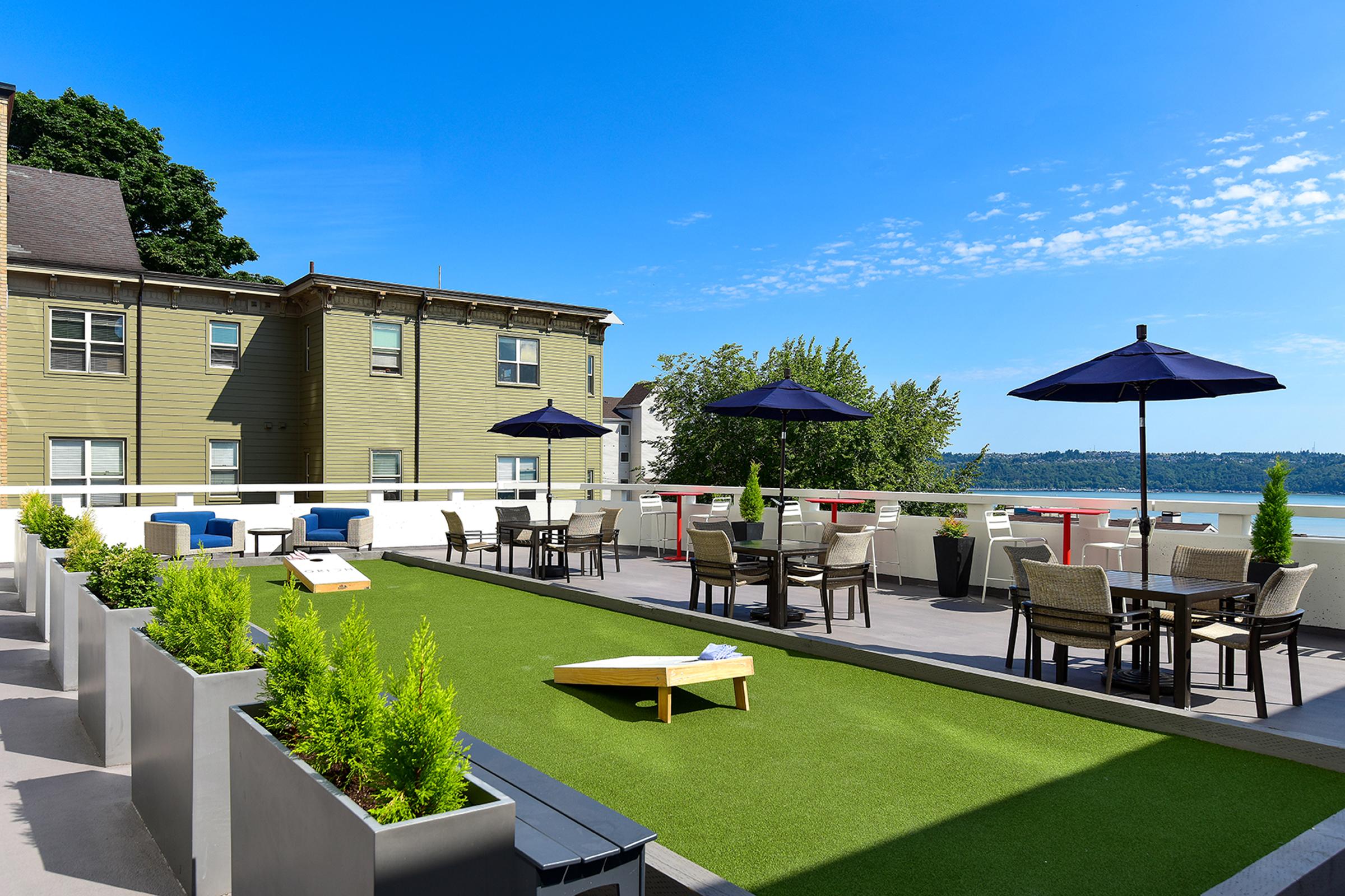 1 BR Apartments in Tacoma WA - Orion - Sundeck with Corn Hole, Dining Areas, Lounge Seating, and a View of the Water