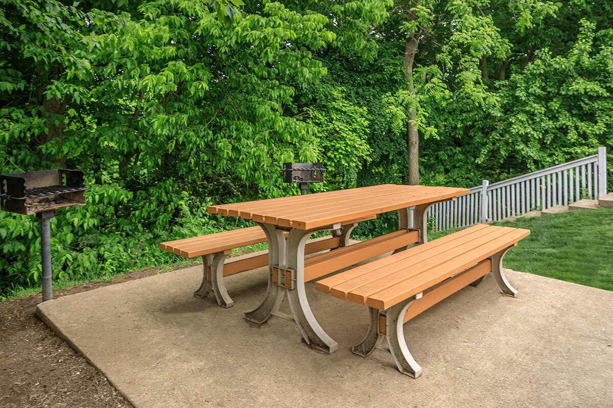 an empty park bench sitting in the grass