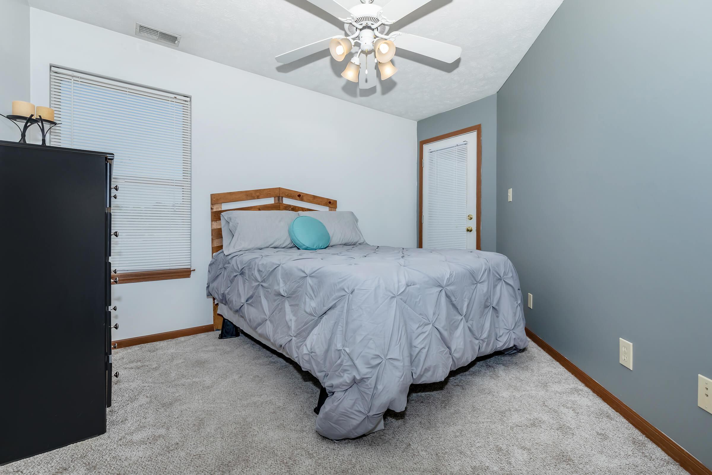 a bedroom with a bed and desk in a room